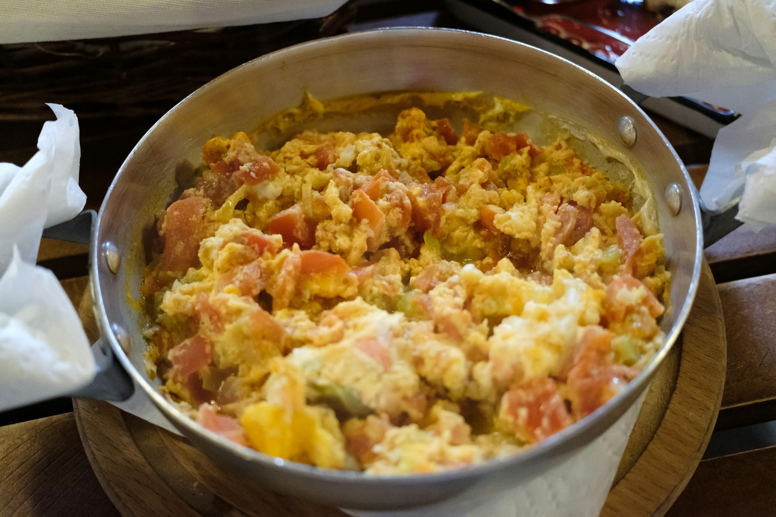 Scrumptious scrambled eggs with fresh tomatoes served in a frying pan.