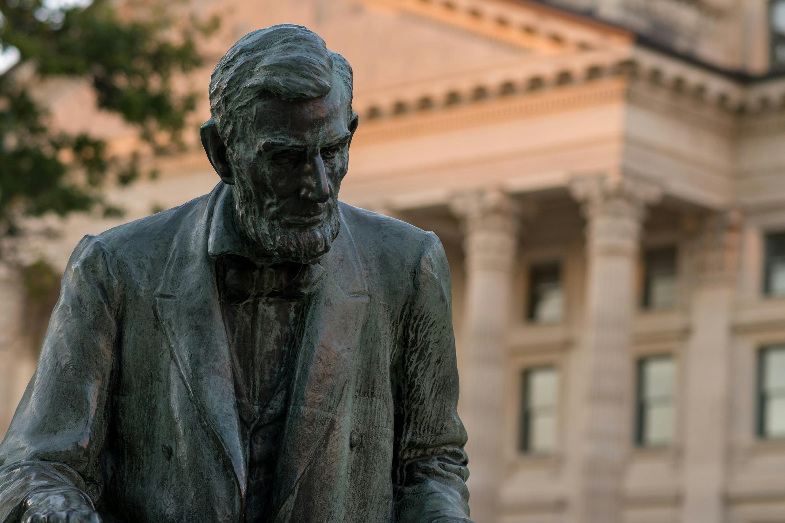 Statue of Abraham Lincoln with a historic architectural backdrop.