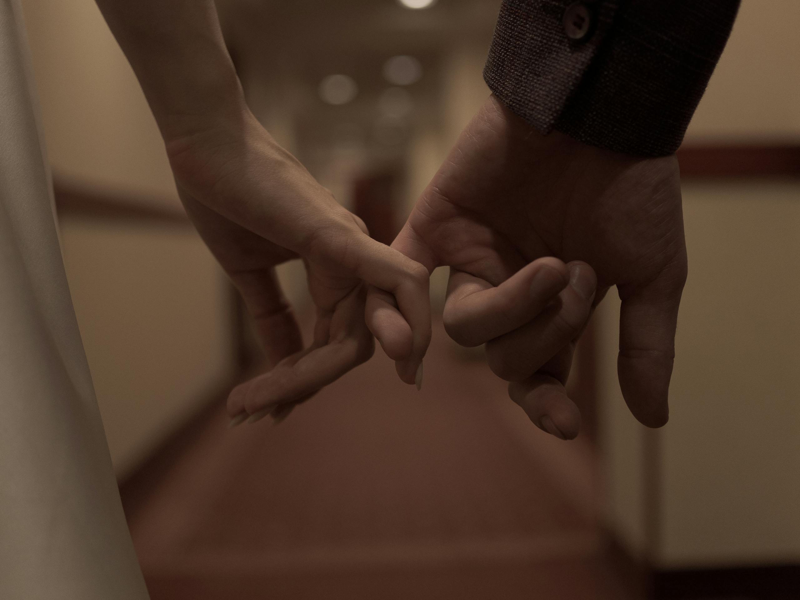 Tender close-up of two hands holding each other, symbolizing love and connection.