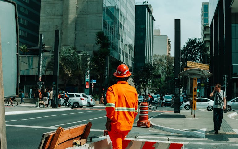 Urban scene in São Paulo with construction worker and bustling street life.