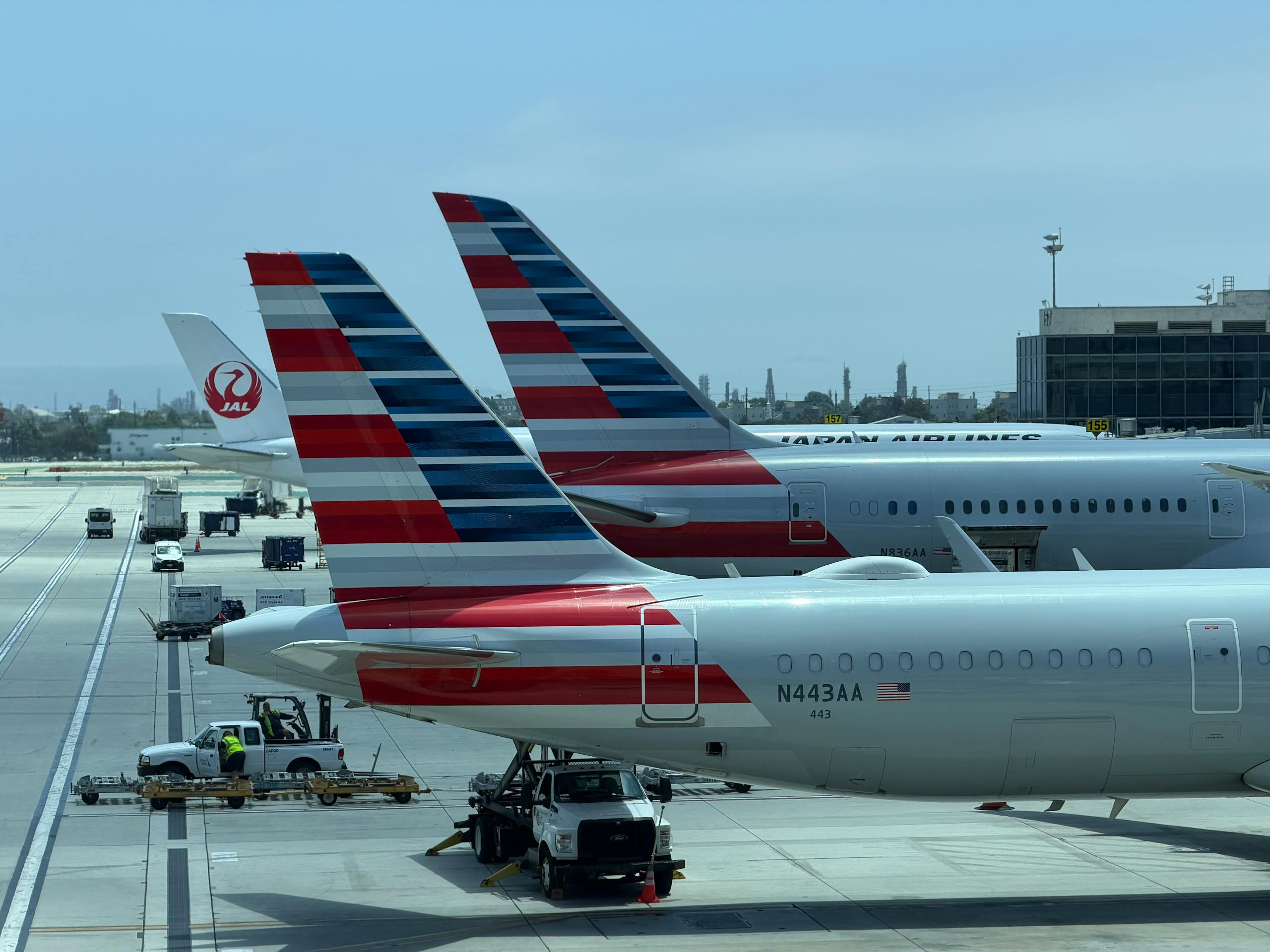 View of multiple airplane tails on the tarmac at Los Angeles International Airport on a clear day.
