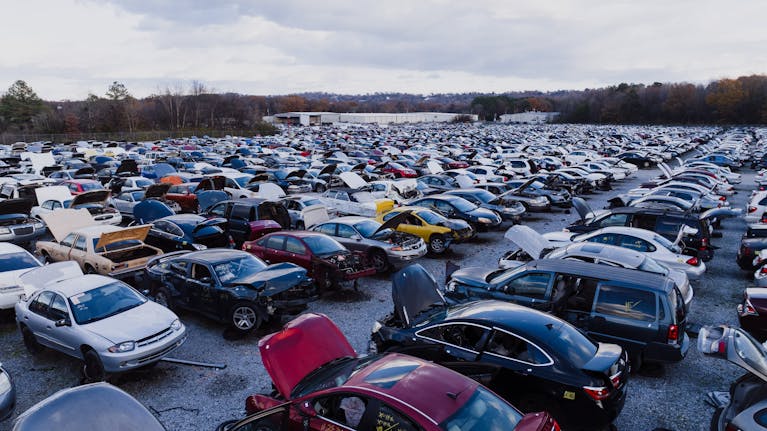 Wide view of a large car junkyard in Chattanooga with numerous vehicles showing signs of wear.