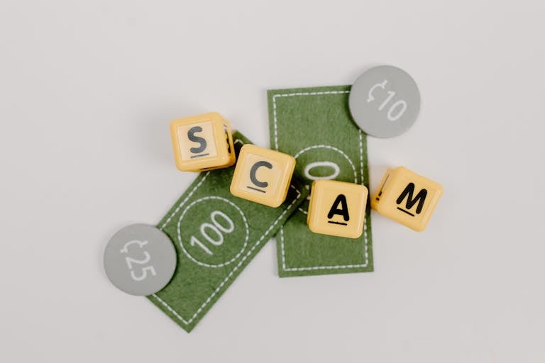 Yellow dice spelling 'Scam' on fake currency, representing financial deception.