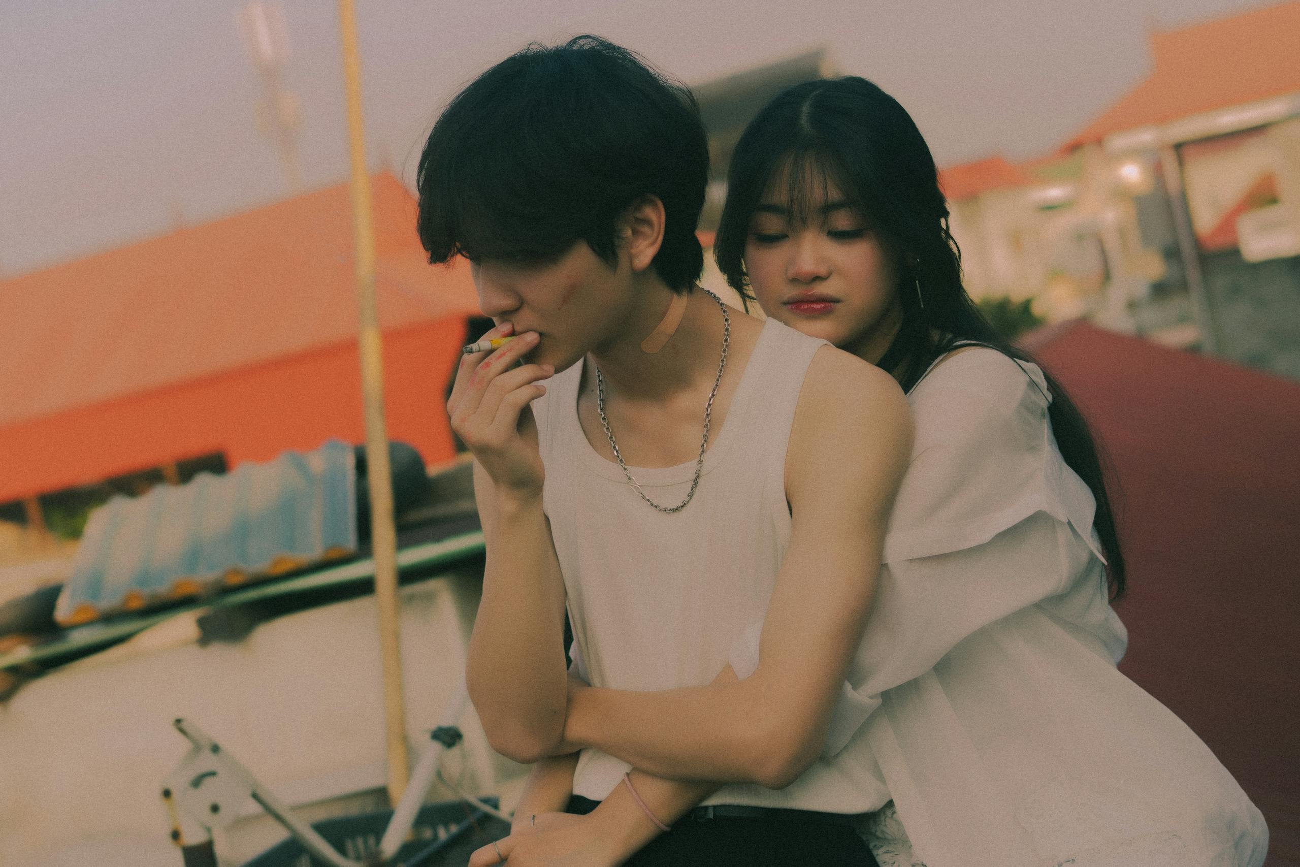 Young couple embracing in an intimate rooftop setting during the day.