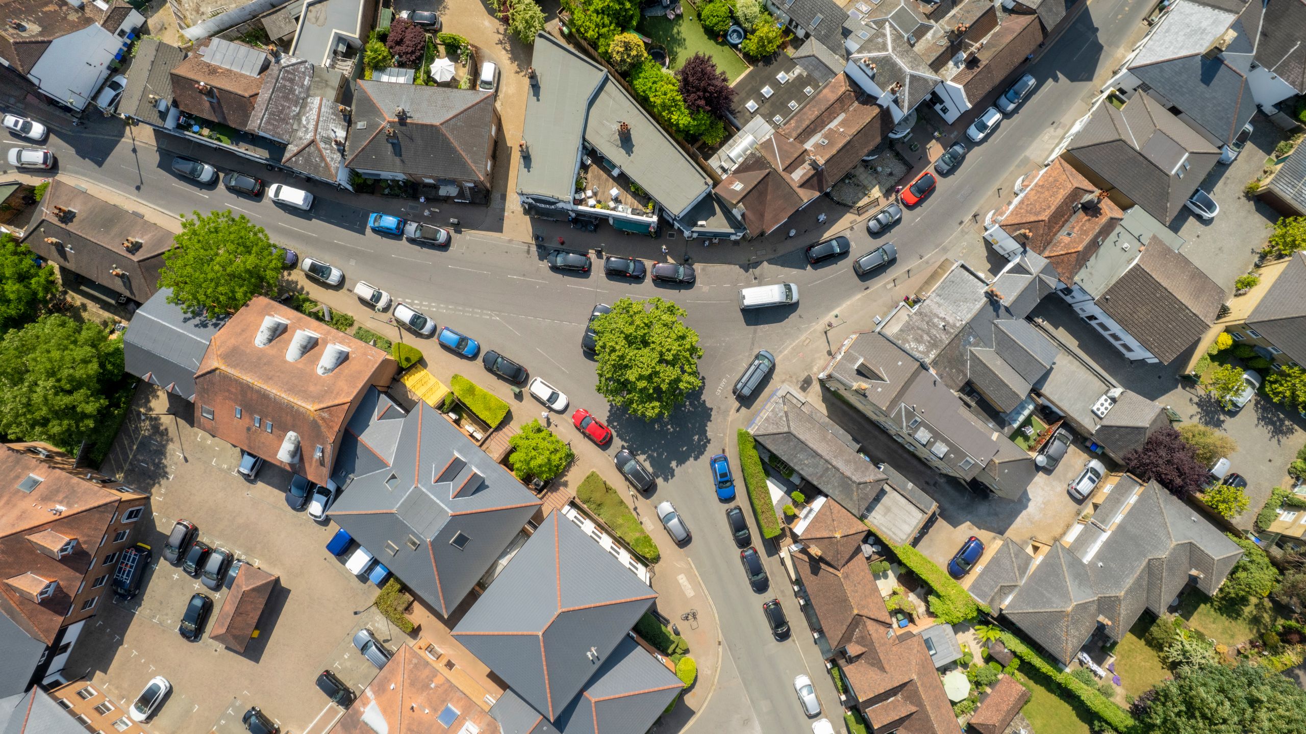 A bird's eye view of Thames Ditton's urban street layout with parked cars, rooftops, and trees.