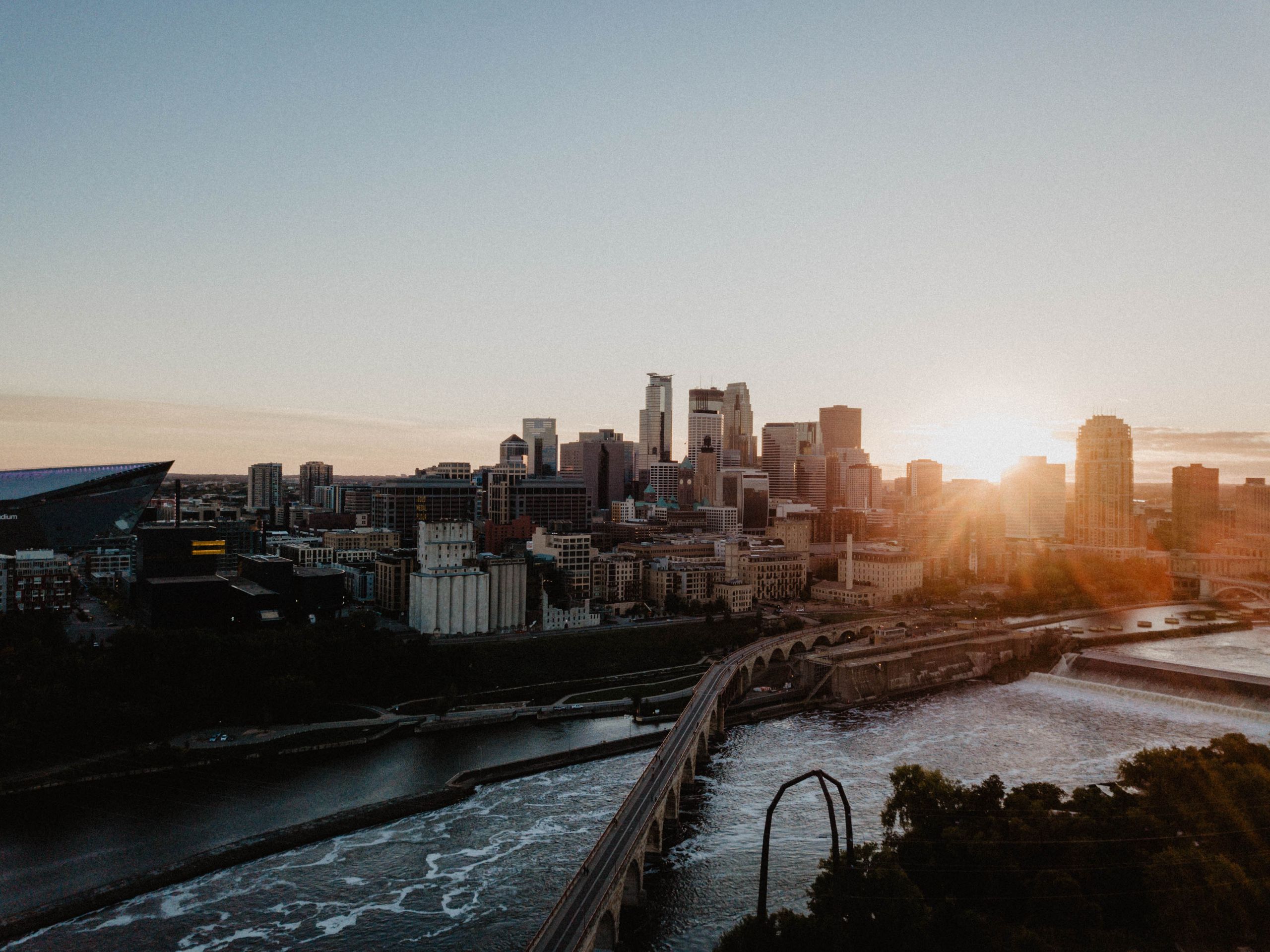 A breathtaking aerial view capturing the Minneapolis skyline with a scenic sunset backdrop.