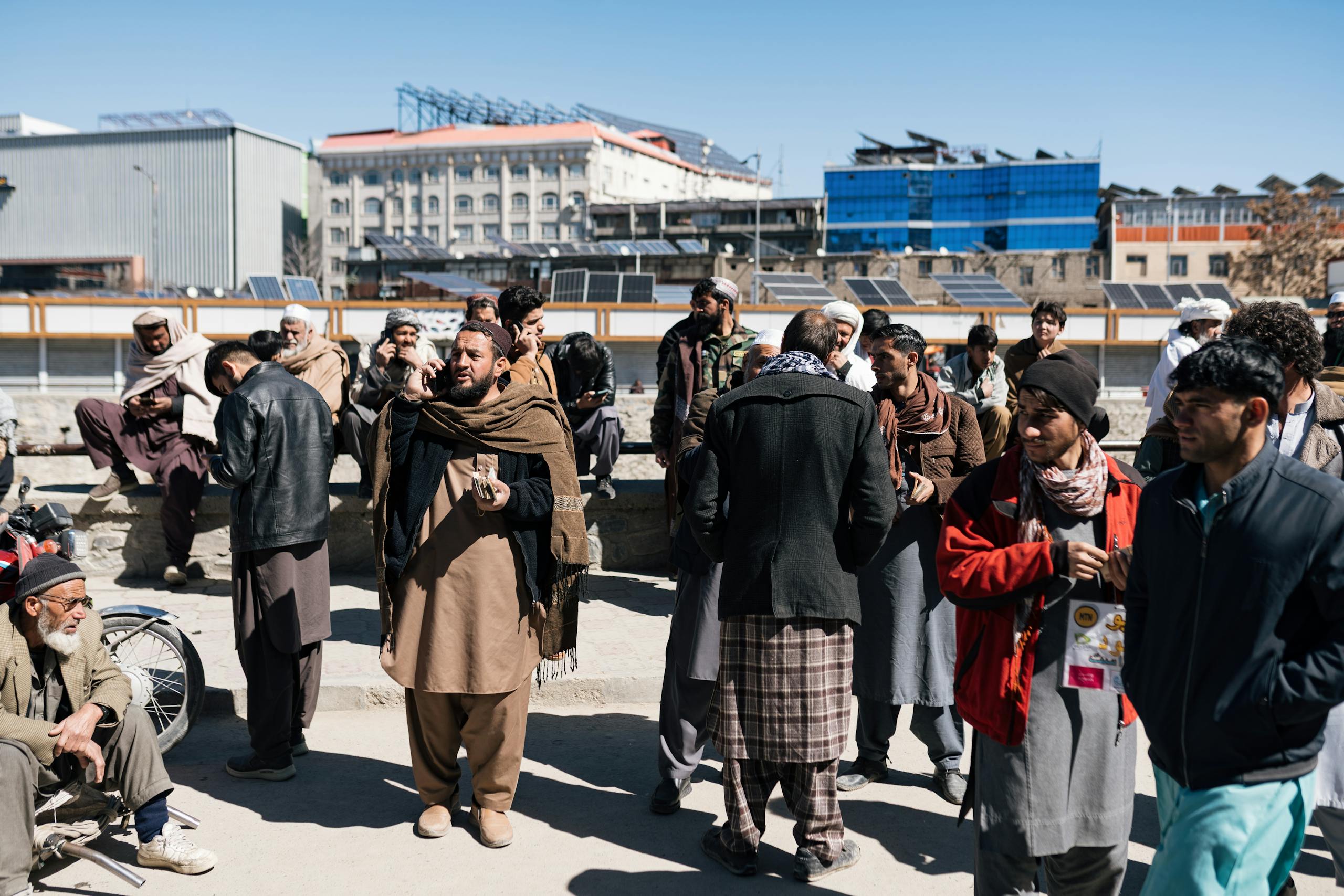 A busy street scene in Afghanistan featuring a diverse group of people outdoors.