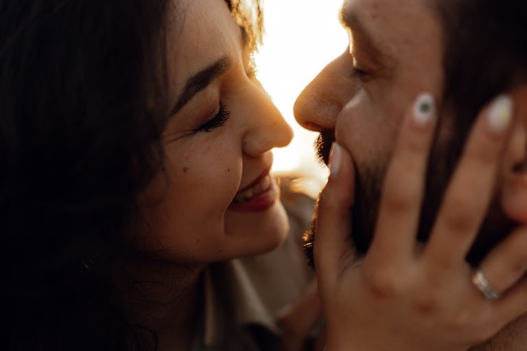 A close-up shot of a happy couple sharing an intimate moment at sunset, showcasing romance and connection.