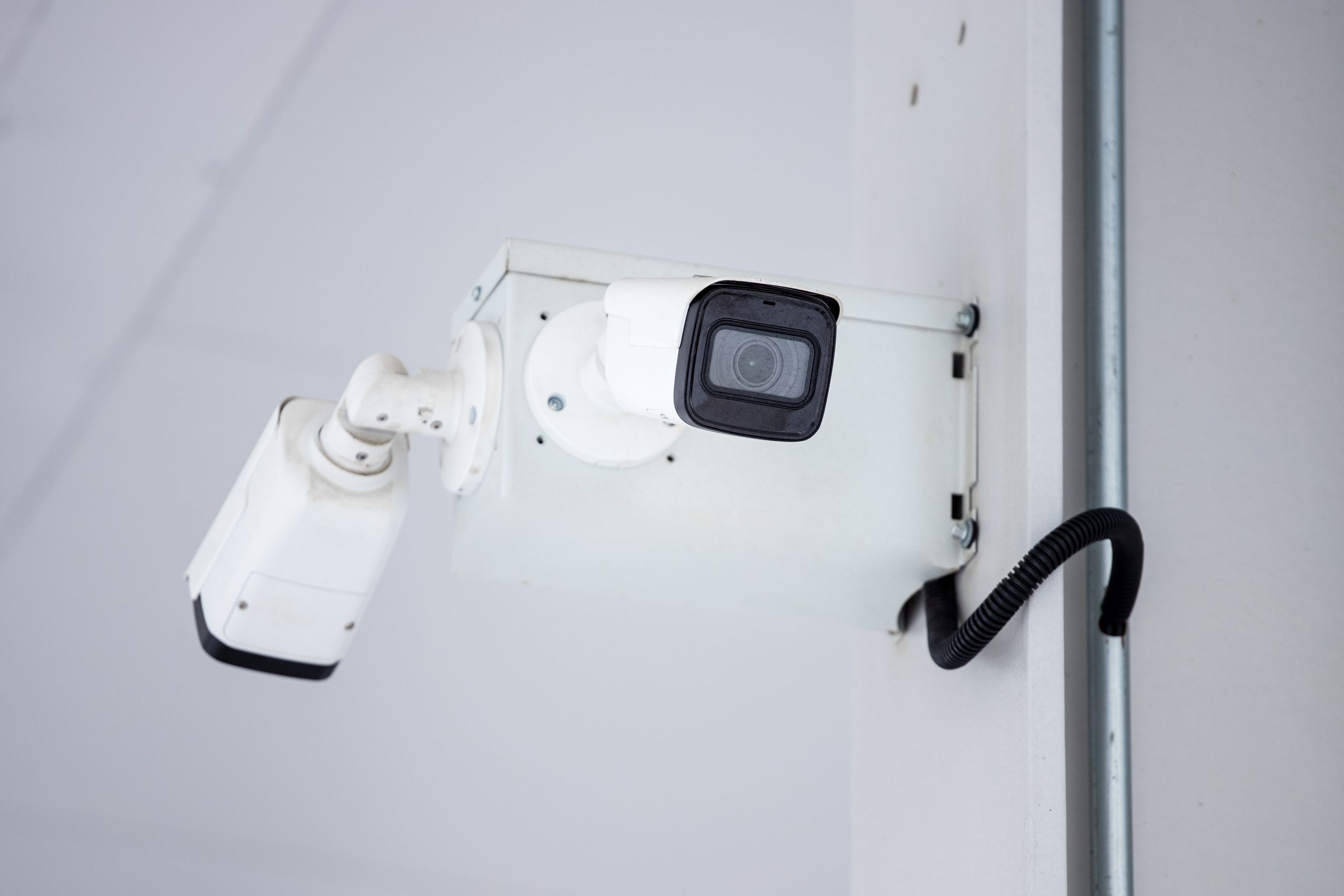 A close-up shot of a modern, mounted surveillance camera highlighting security and surveillance.