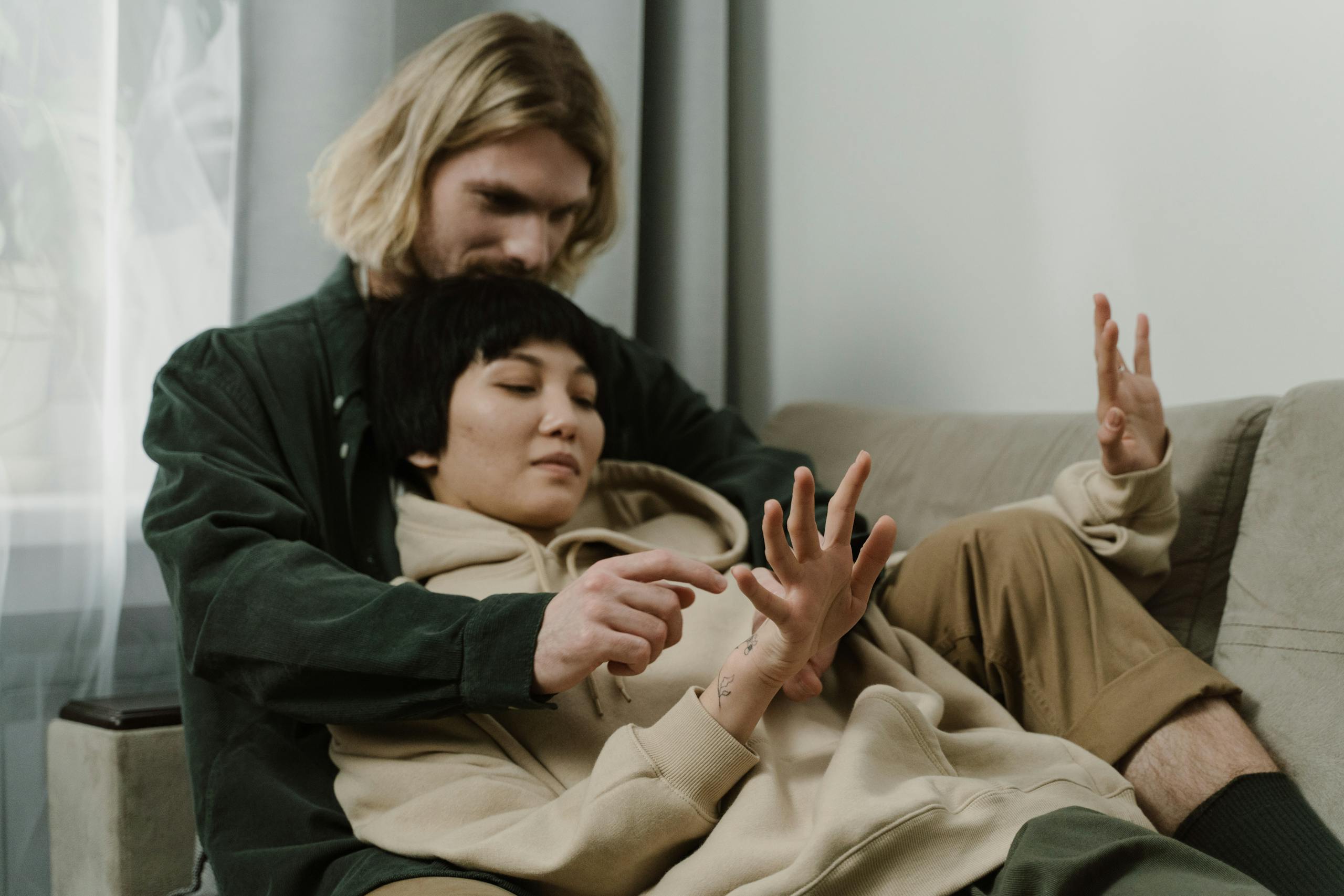 A couple enjoying a quiet and intimate moment on a cozy sofa indoors.
