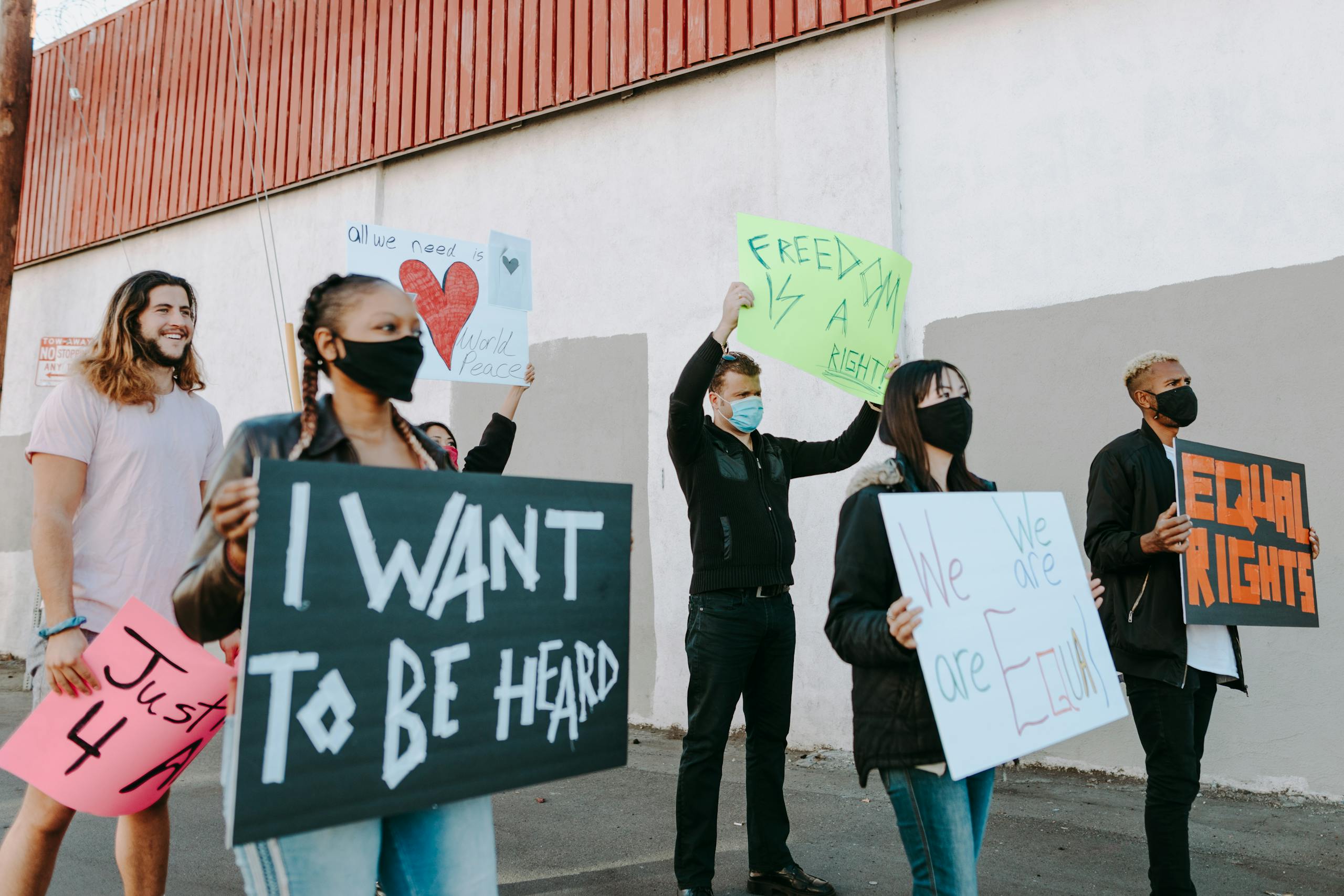 A diverse group of people rallying for equality, holding signs advocating for freedom and equal rights.