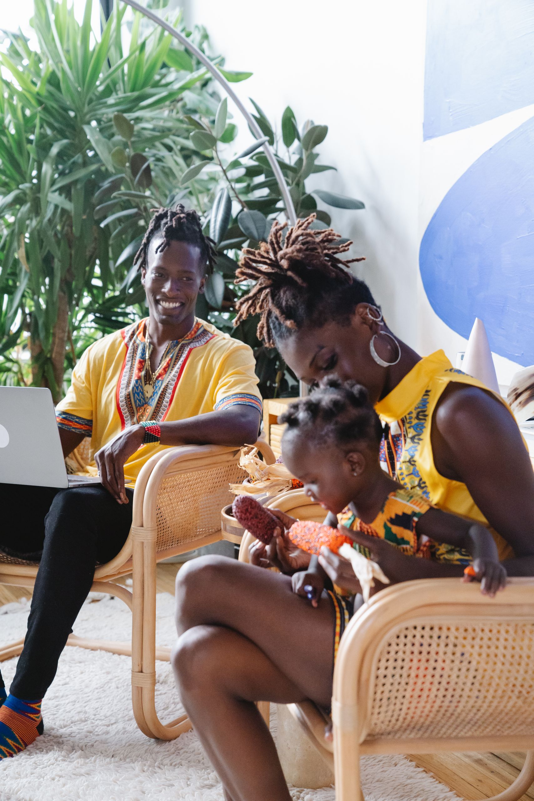 A family enjoying time together indoors, wearing colorful traditional clothing.