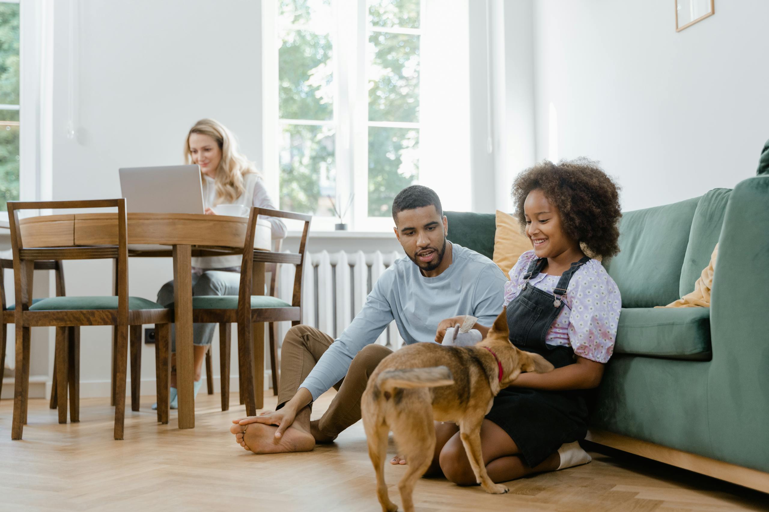 A family spending quality time with their dog in a bright living room setting.