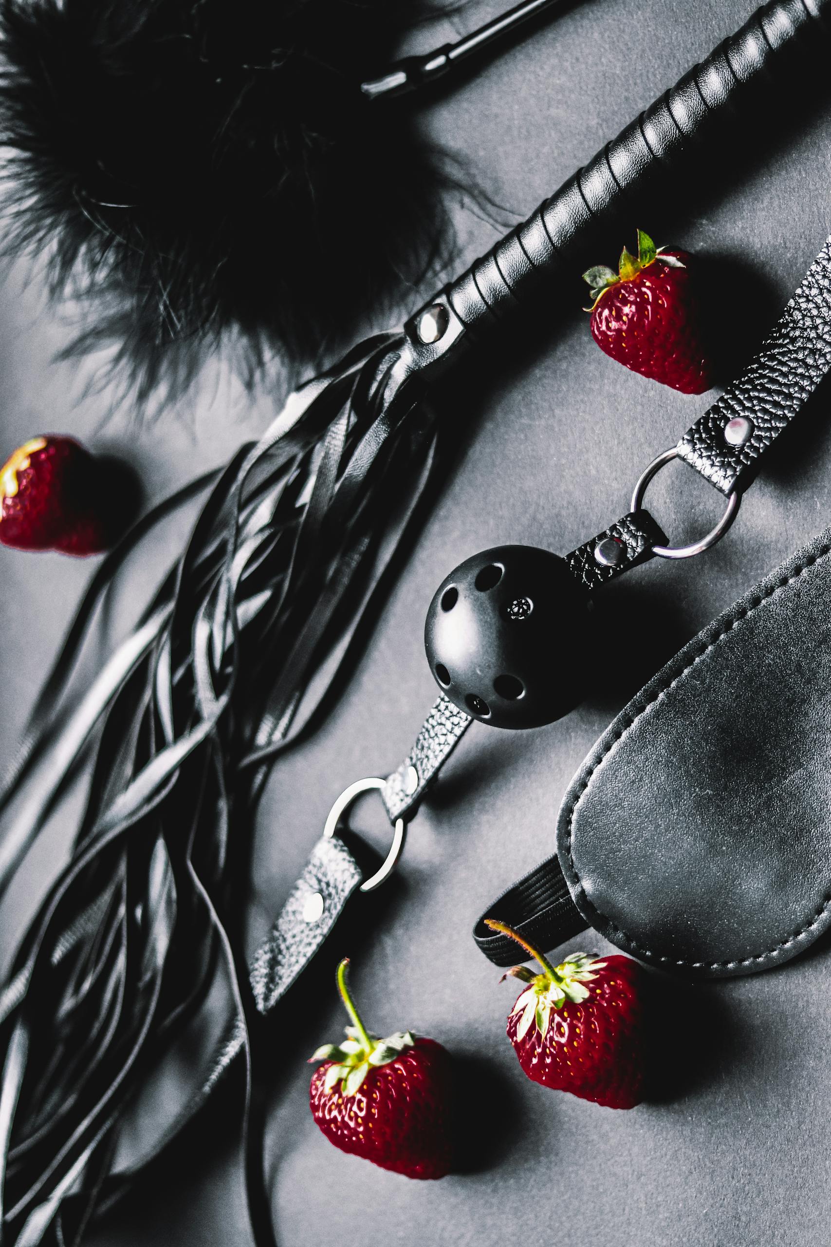 A flat lay of sensual accessories with strawberries, creating an intimate and provocative composition.