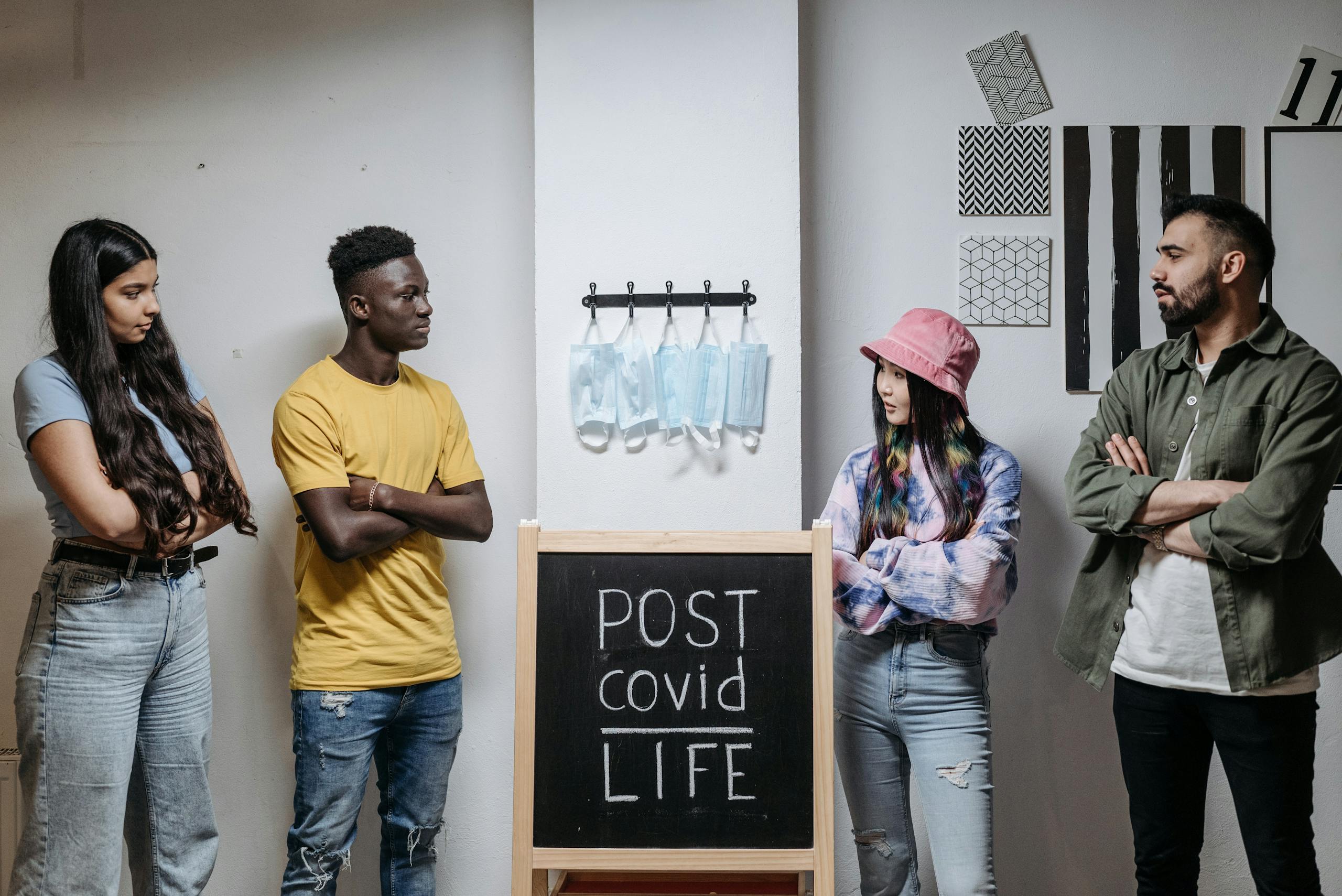 A group of diverse adults discussing life after COVID-19 indoors, highlighting socialization and safety.