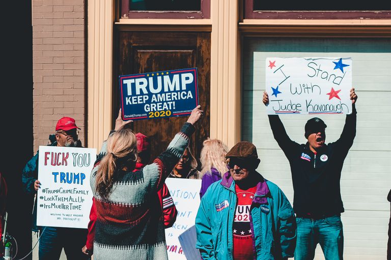 A group of people at a political rally in Wheeling, West Virginia, supporting different 2020 election campaigns.