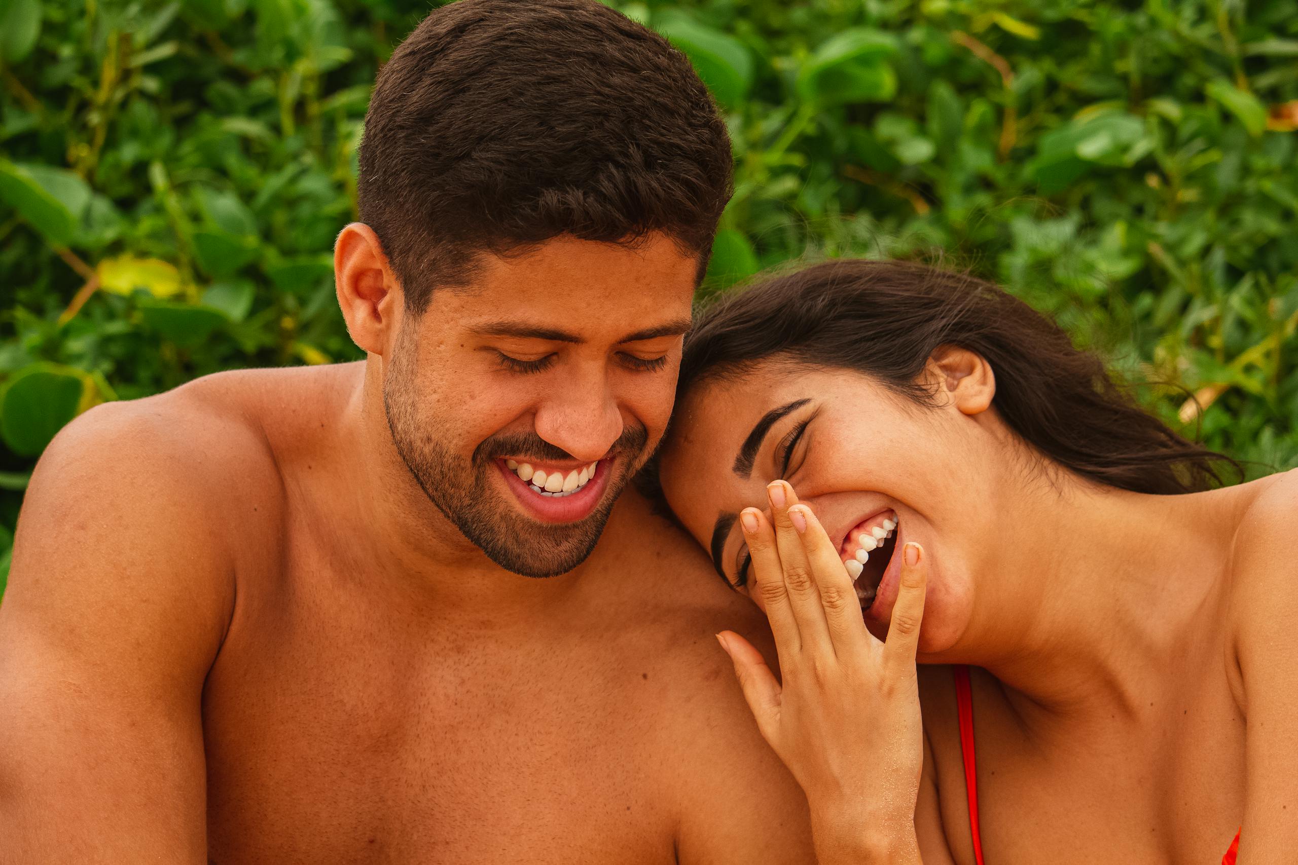 A happy couple enjoying a cheerful moment outdoors during summer.