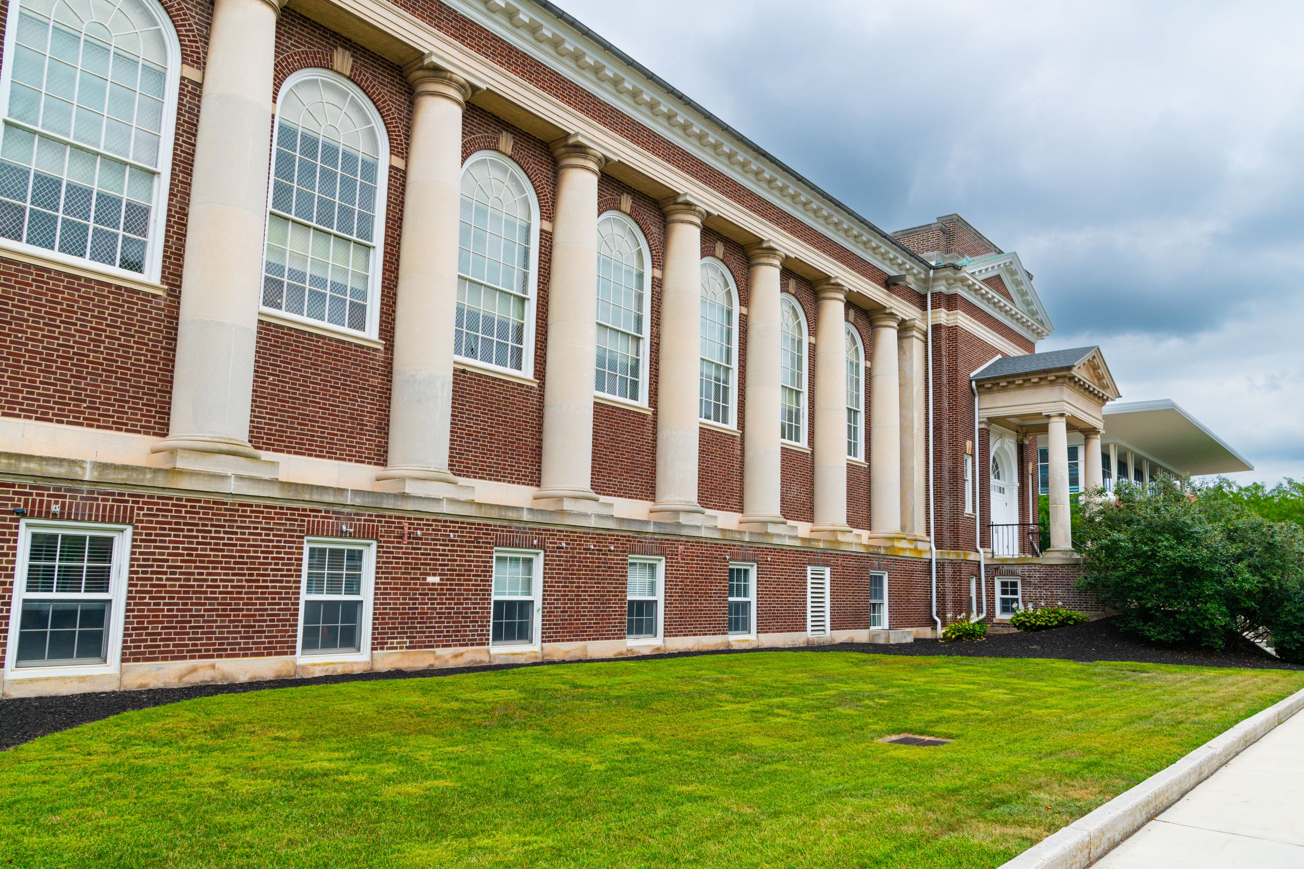 A historic brick building with columns in Gettysburg on a cloudy day.