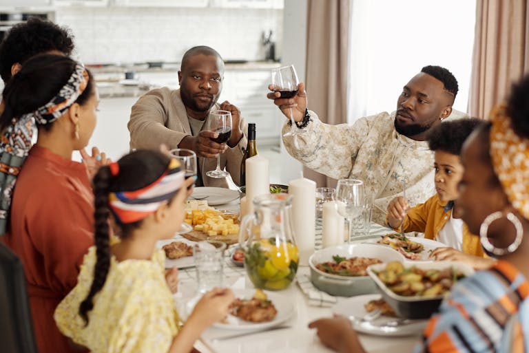 A joyful family dinner with wine toasts bringing together adults and children in a warm home setting.