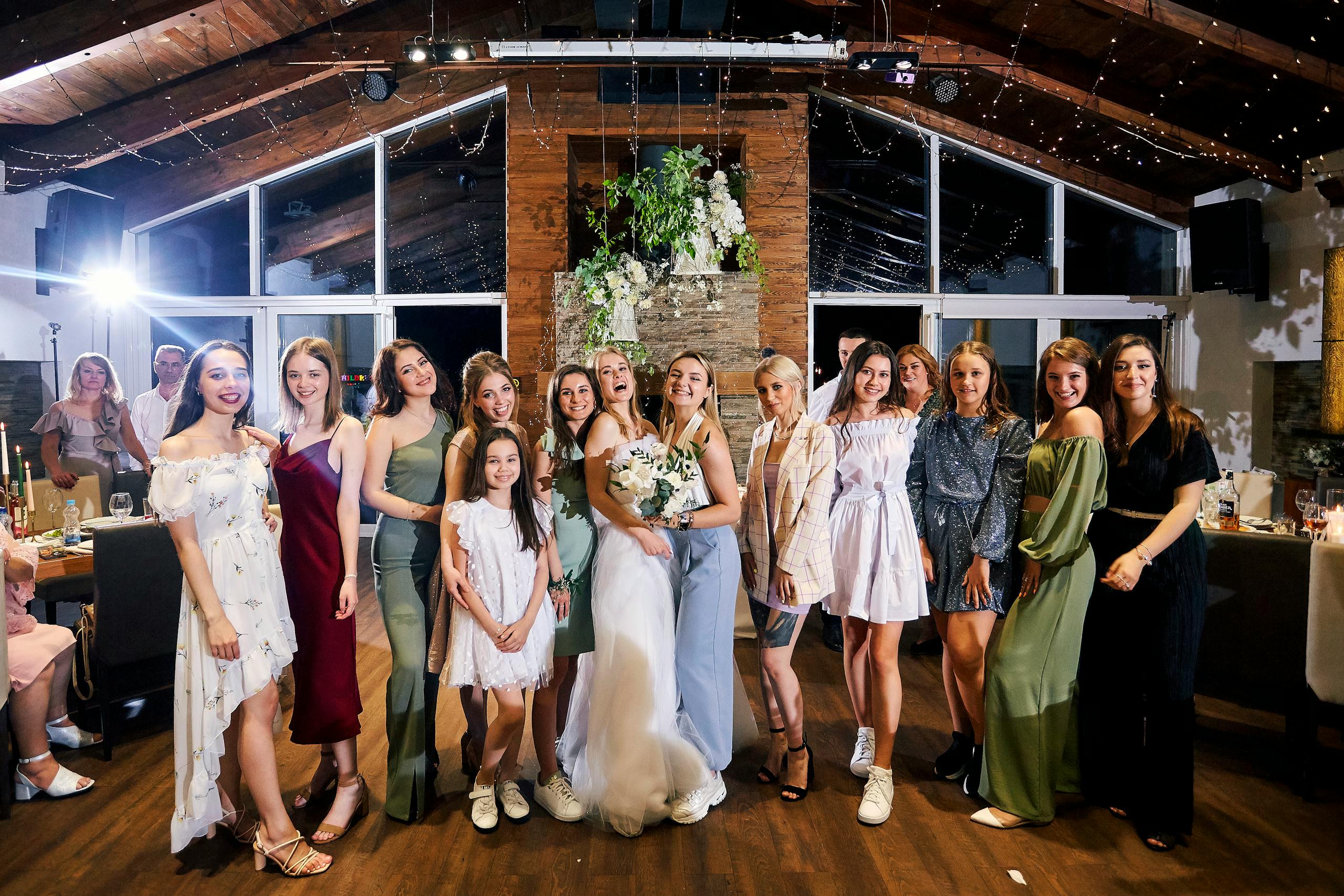 A joyful group portrait of women celebrating at a modern wedding reception.
