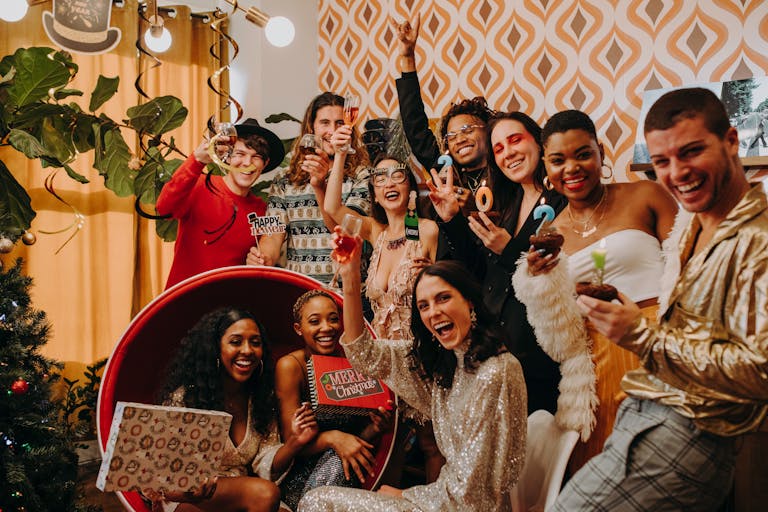 A lively party scene with a diverse group celebrating New Year's Eve indoors with drinks and decorations.
