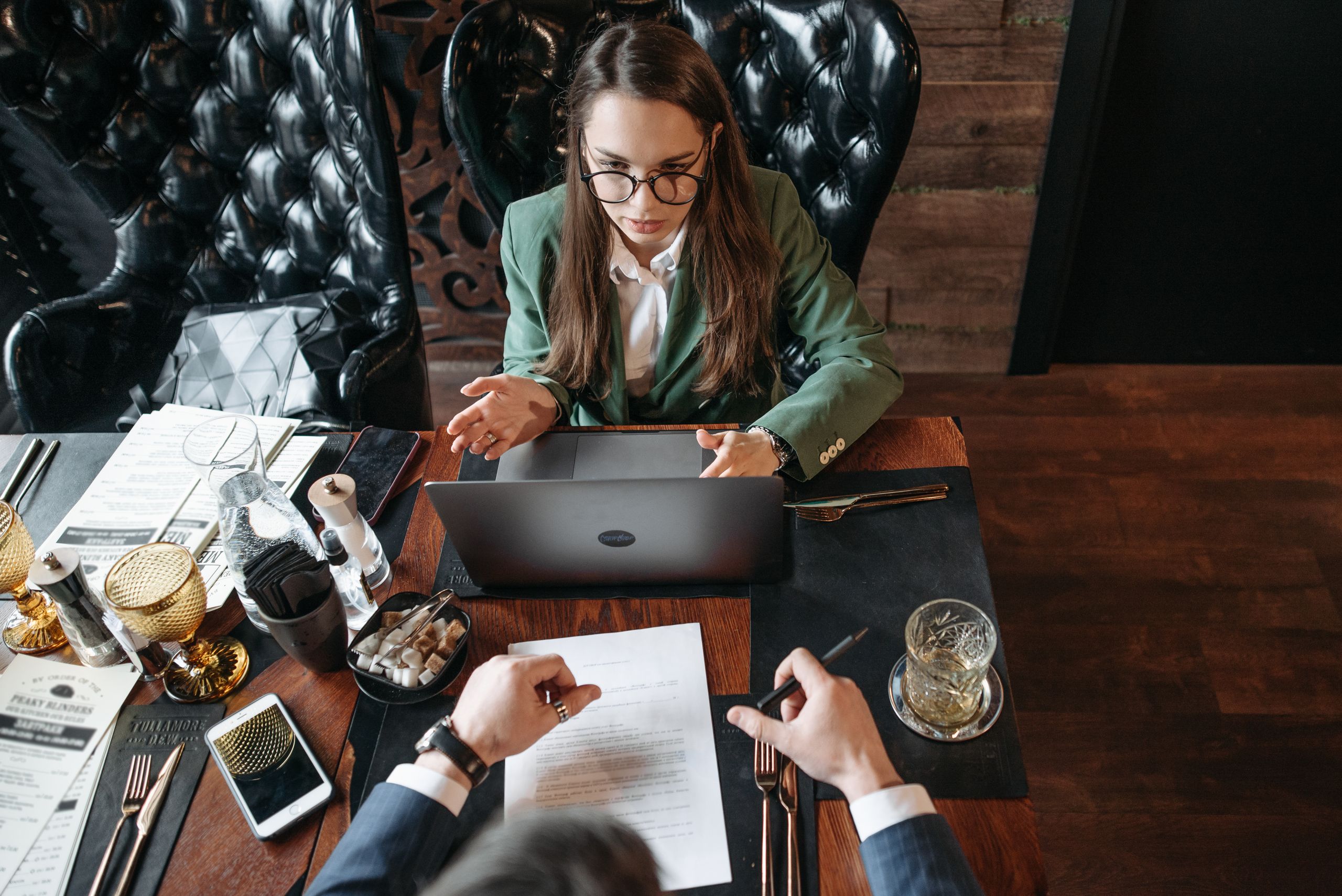 A professional business meeting with a woman explaining ideas at a restaurant table.