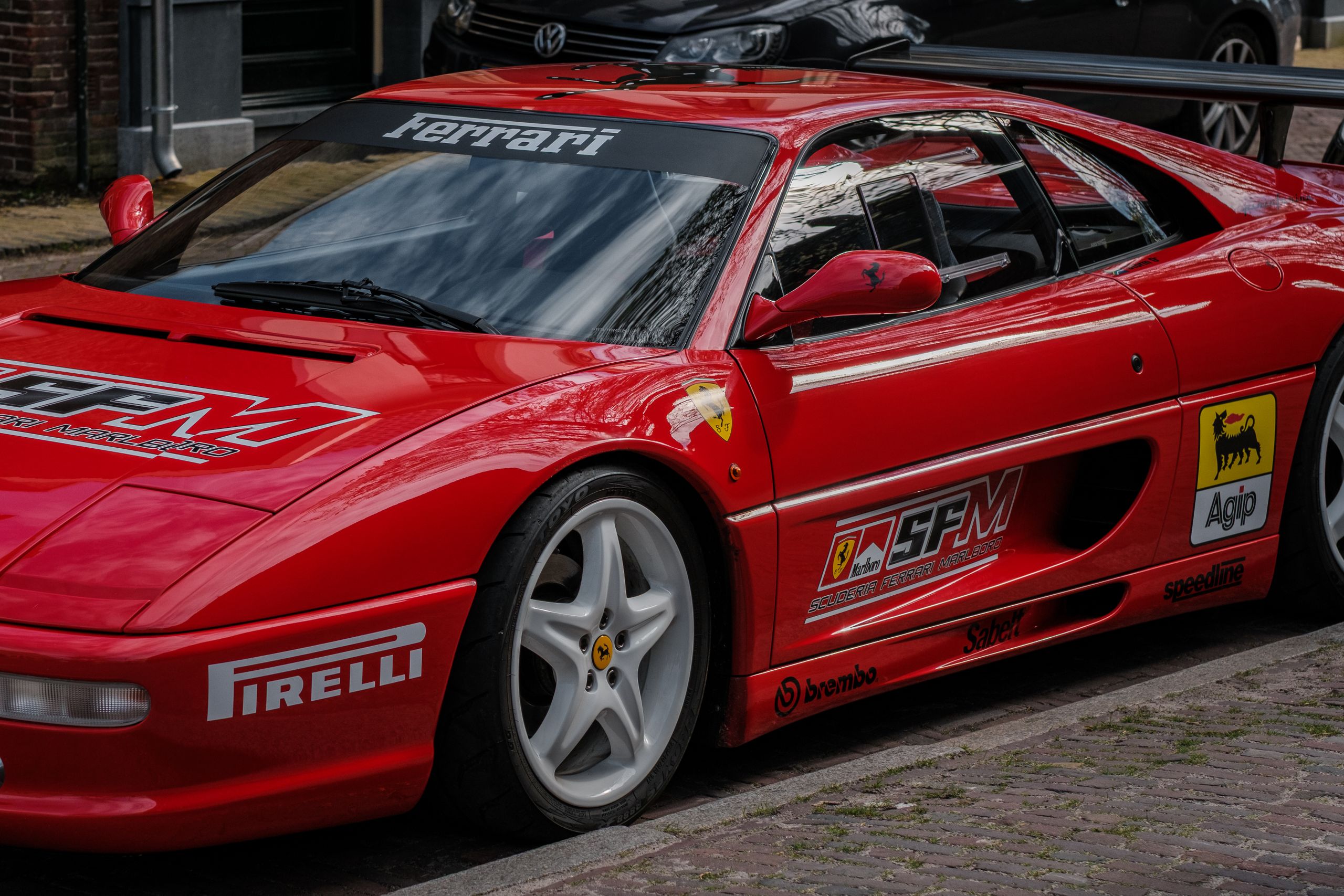A striking red Ferrari racing car parked on a city street, showcasing its sleek design and automotive elegance.