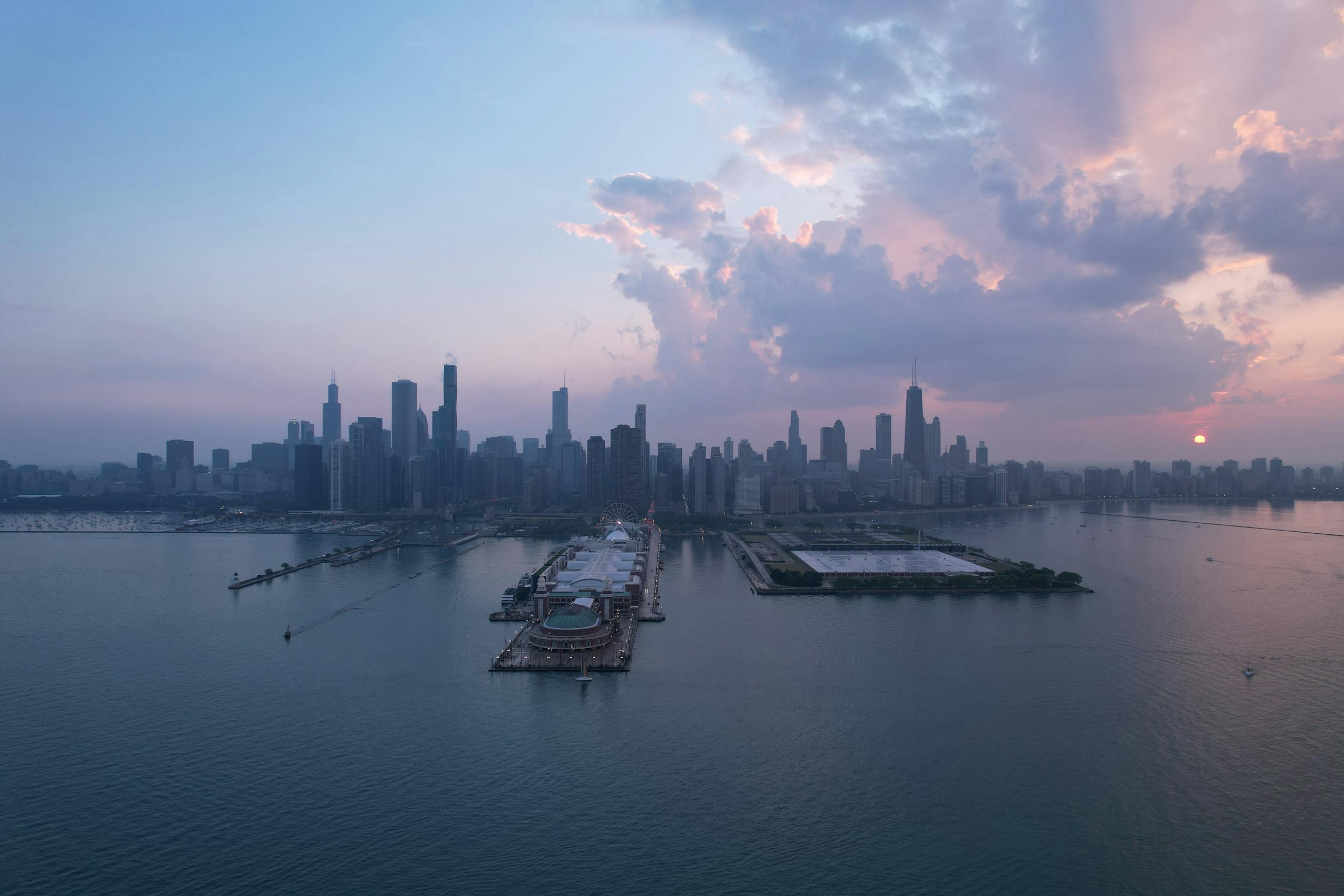A stunning aerial view of Chicago's skyline at sunset with Navy Pier in the foreground.