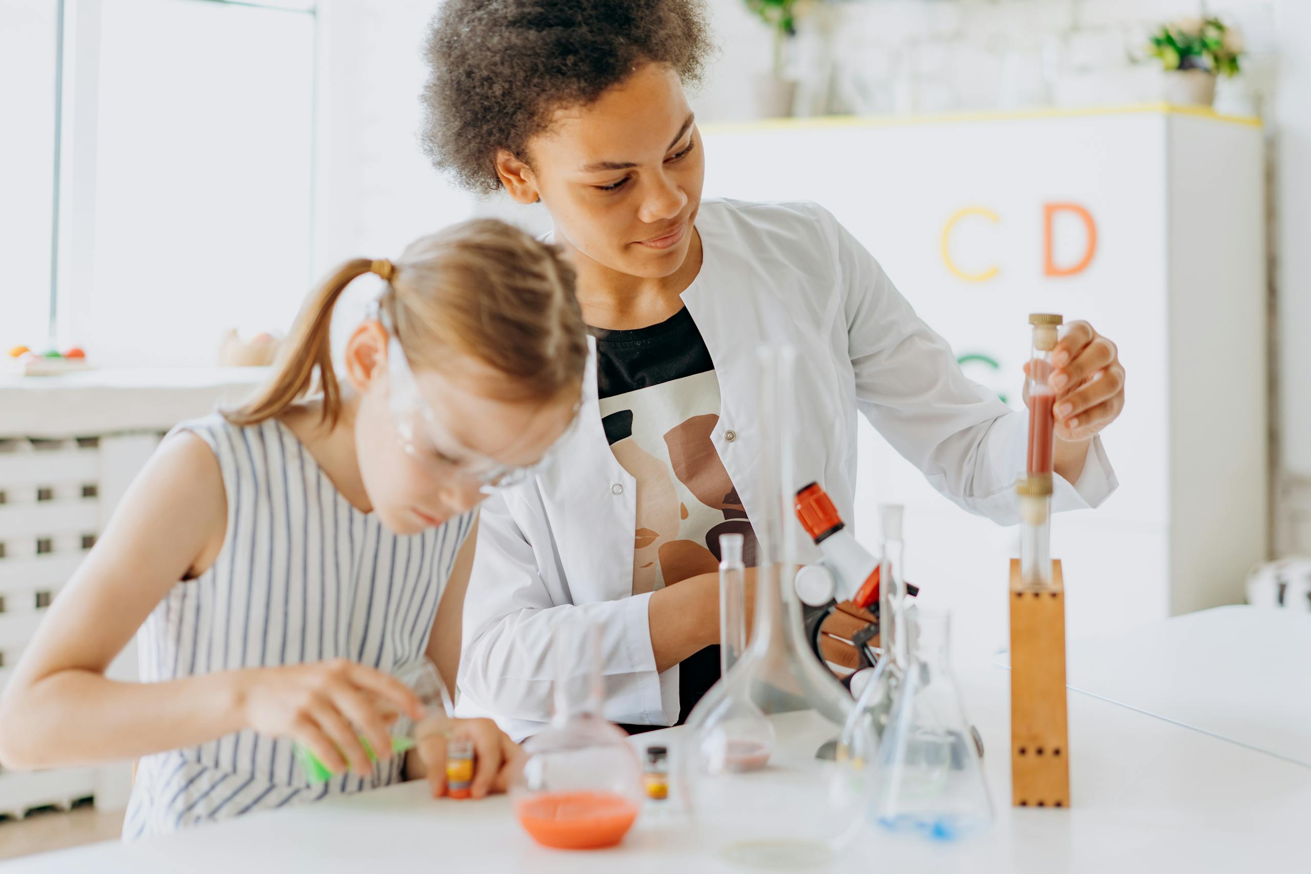 A teacher and student engage in a hands-on science experiment in a classroom setting.