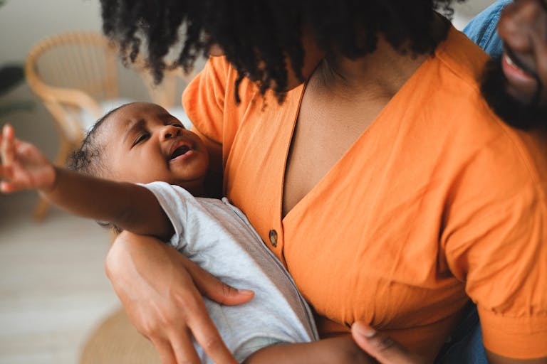A tender moment between a mother and her baby indoors, showcasing love and closeness.