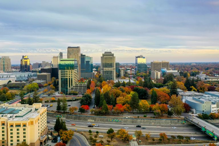 A vibrant aerial view of Sacramento's skyline showcasing fall foliage and modern architecture.