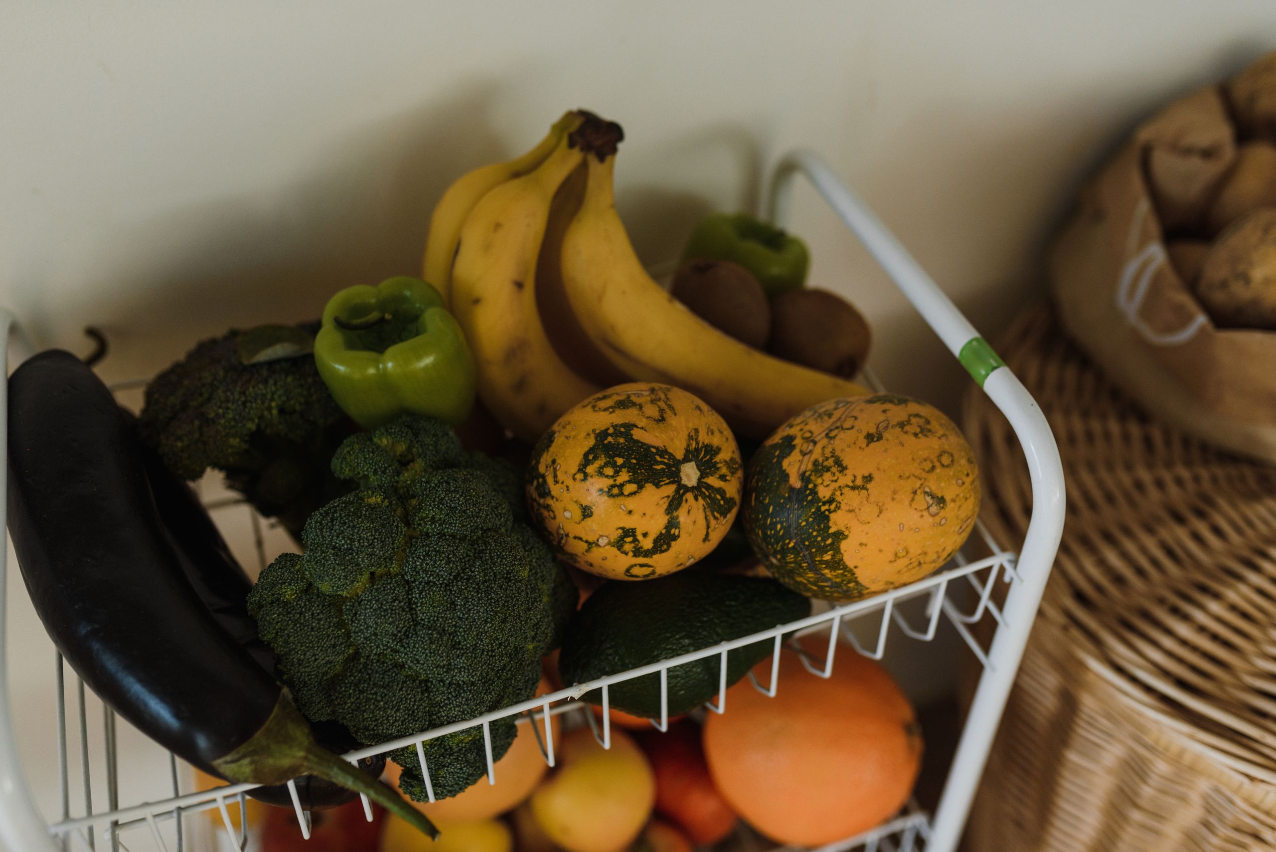 A vibrant assortment of fruits and vegetables on a kitchen rack, showcasing health and nutrition.