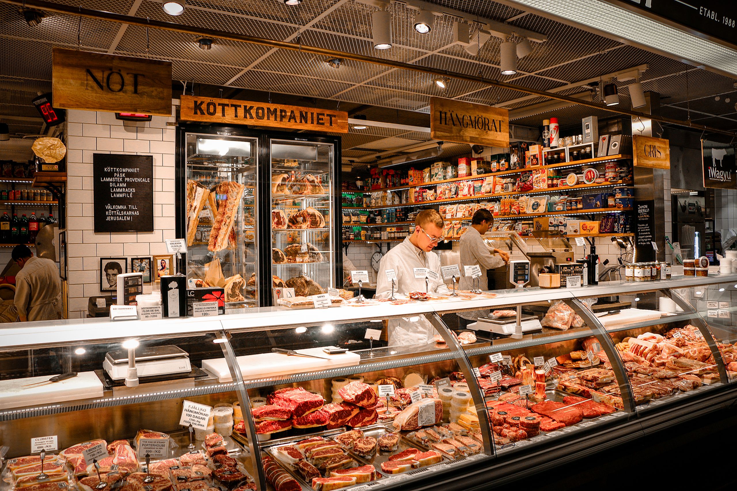 A vibrant butcher shop counter in Stockholm, Sweden, featuring various fresh meats and products.