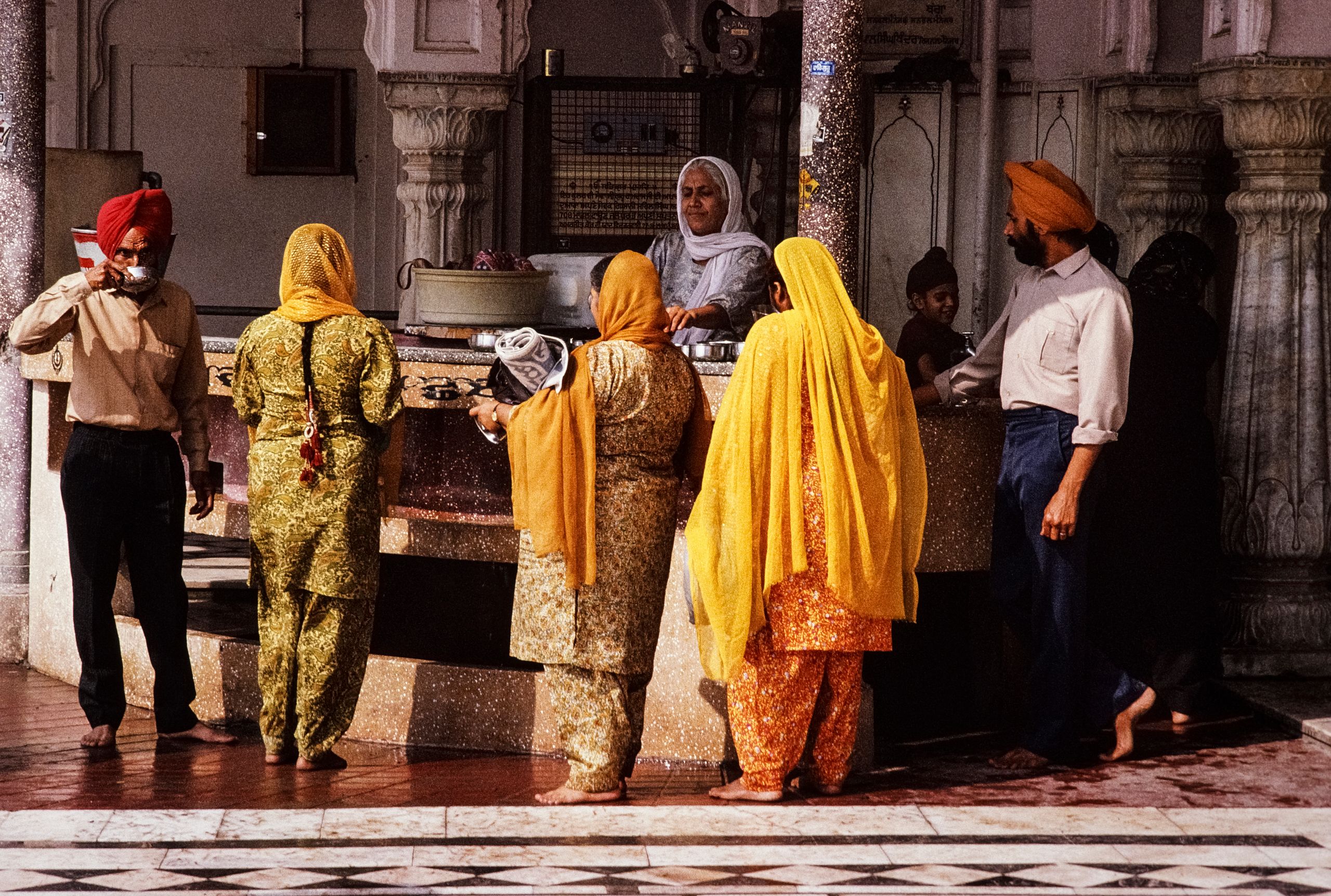 A vibrant scene capturing people at a Sikh temple in India, showcasing cultural tradition.
