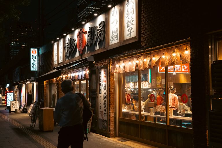 A vibrant Tokyo street scene at night showcasing a traditional Japanese restaurant.