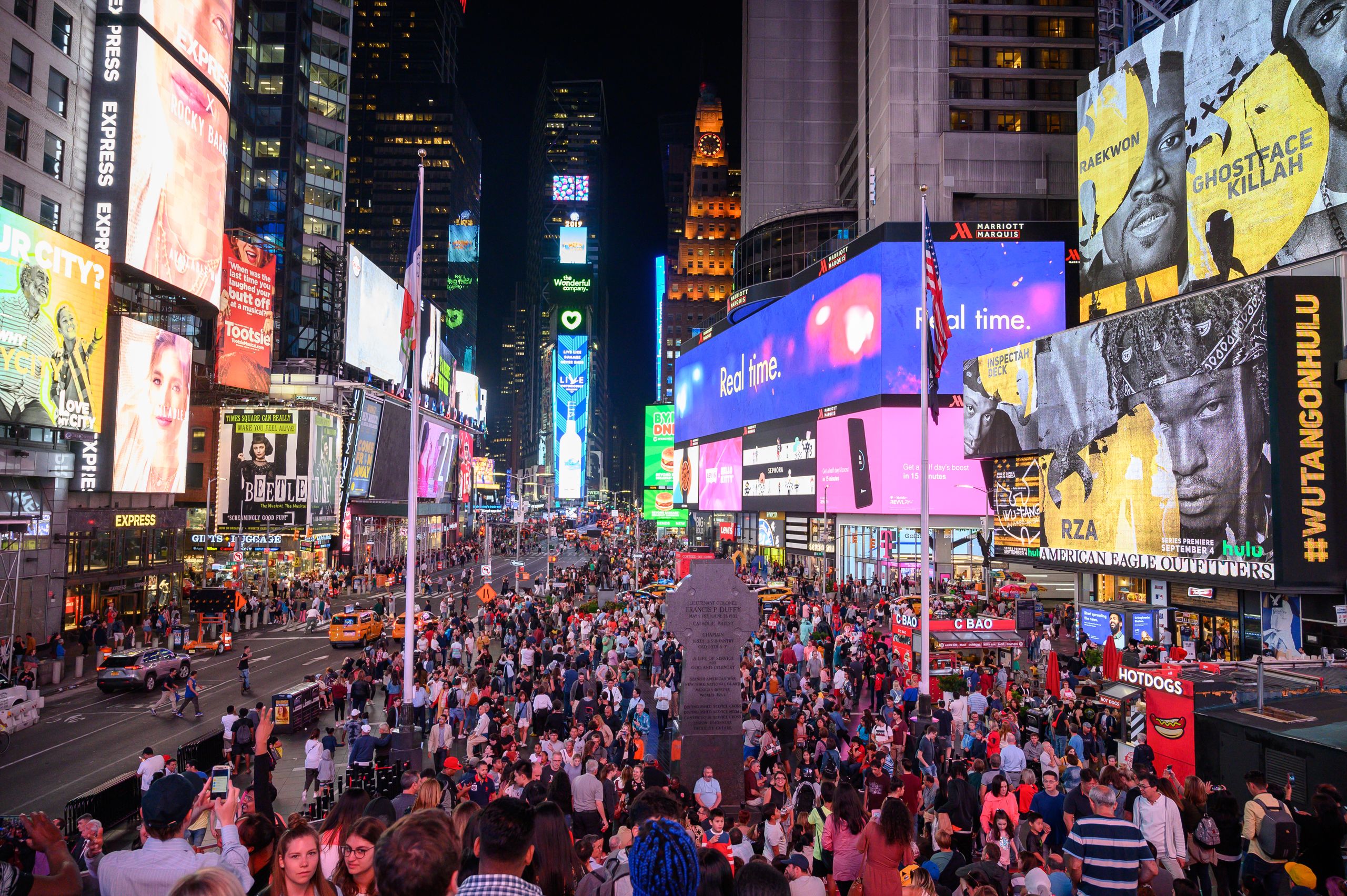 A view of the bustling Times Square filled with crowds and bright billboards at nighttime.
