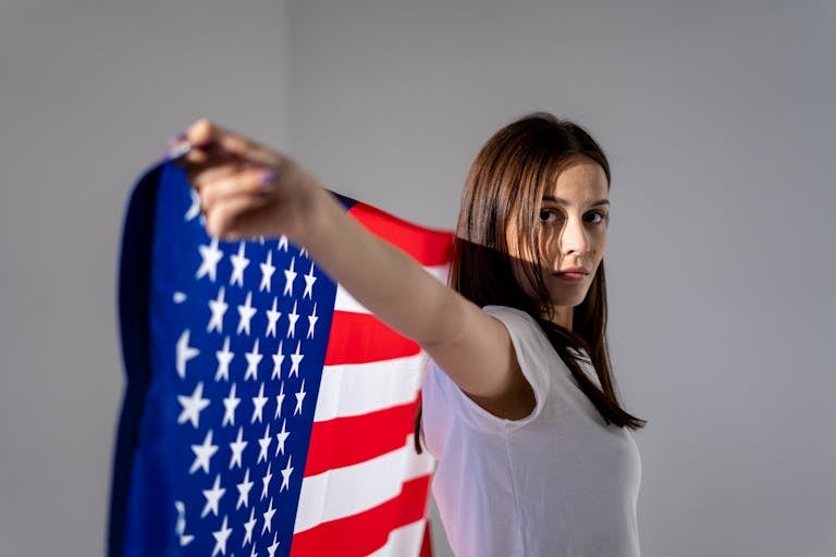 A woman holding the American flag, symbolizing patriotism and independence.