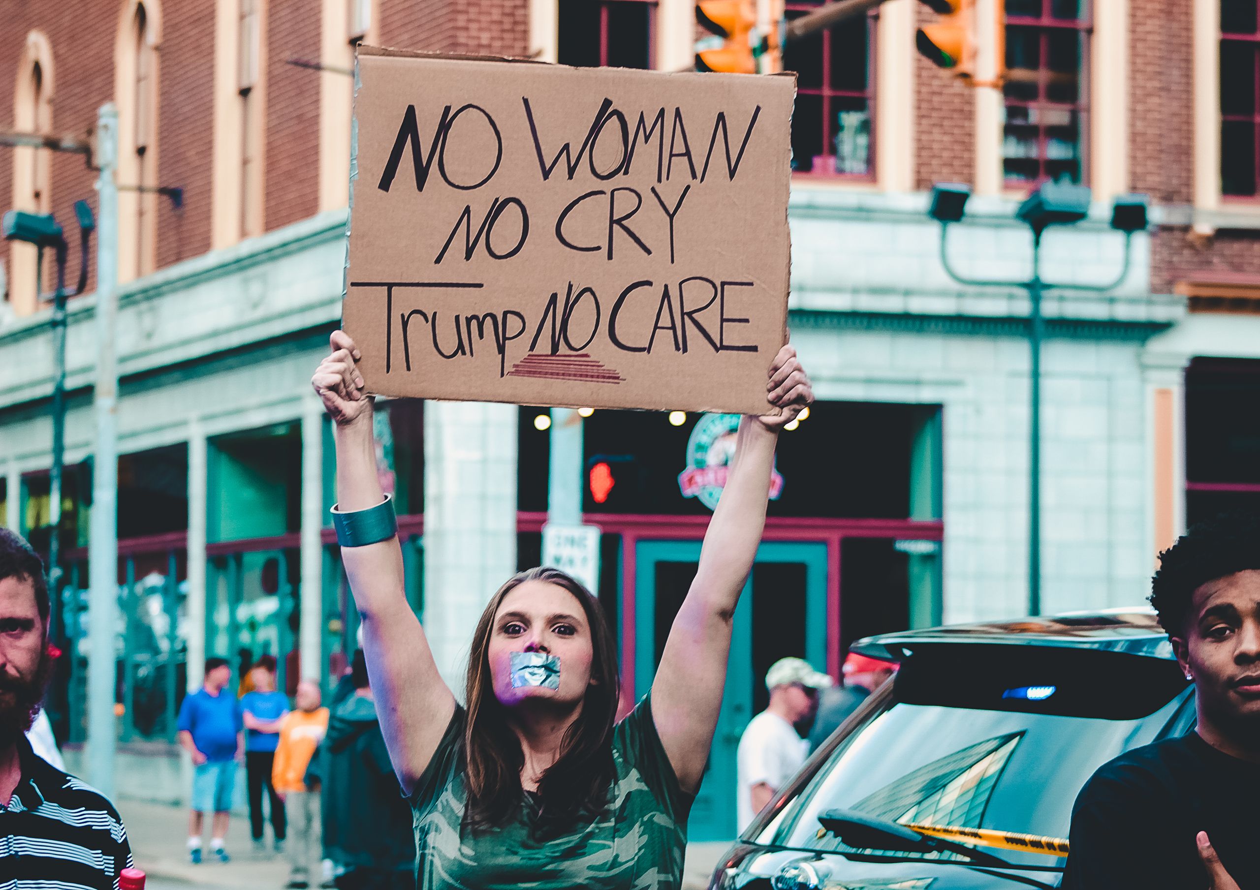 A woman holds a protest sign in a street rally in Wheeling, WV.