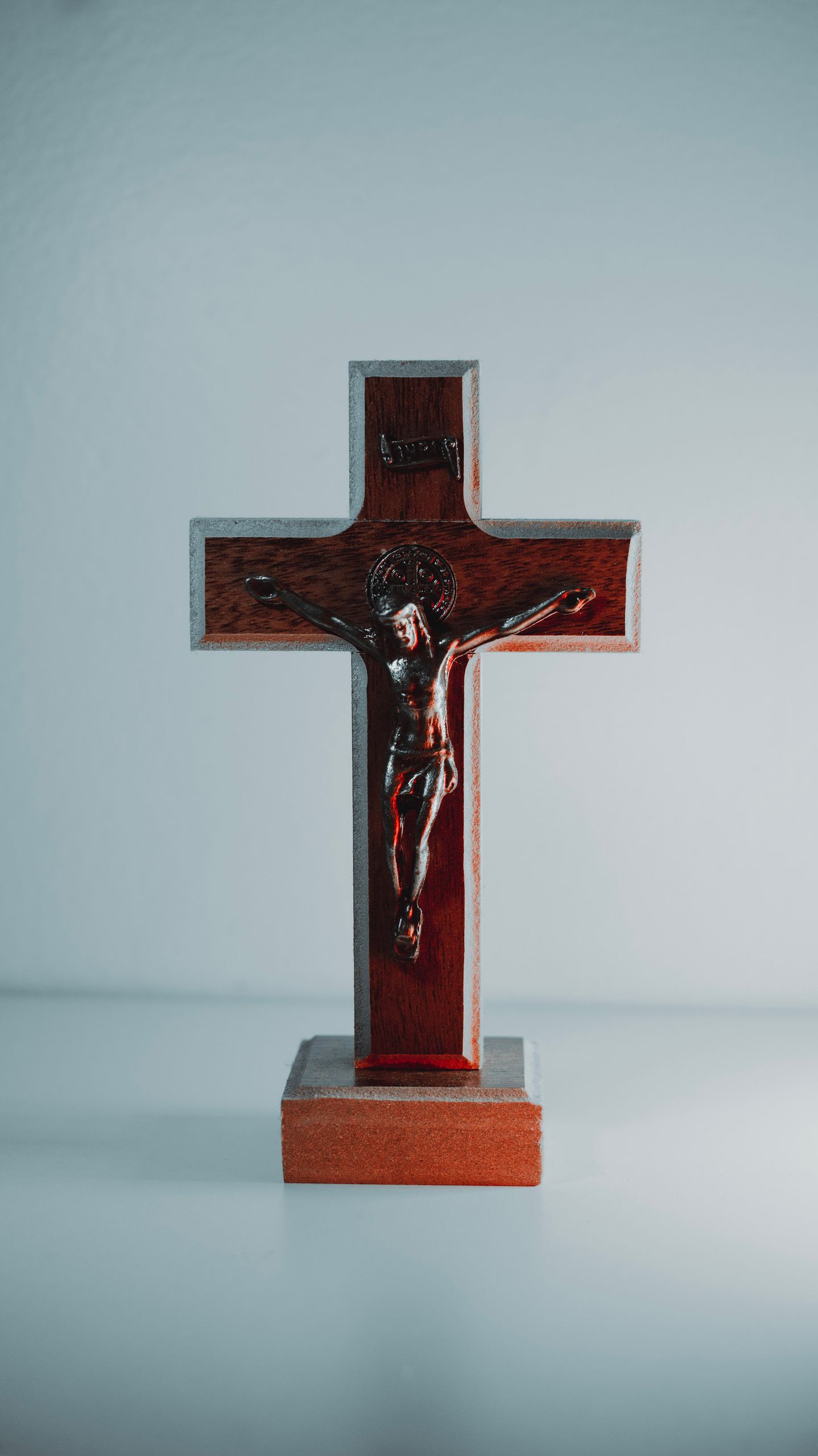 A wooden crucifix depicting Jesus Christ against a plain white background.
