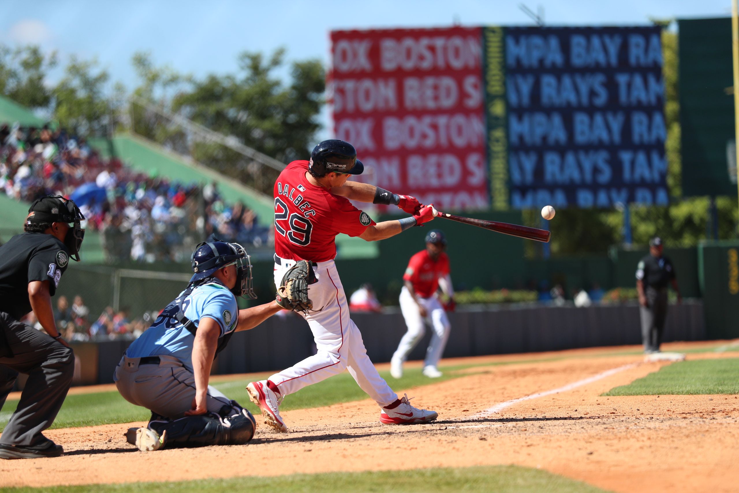 Action-packed baseball game in Santo Domingo, capturing a powerful swing.