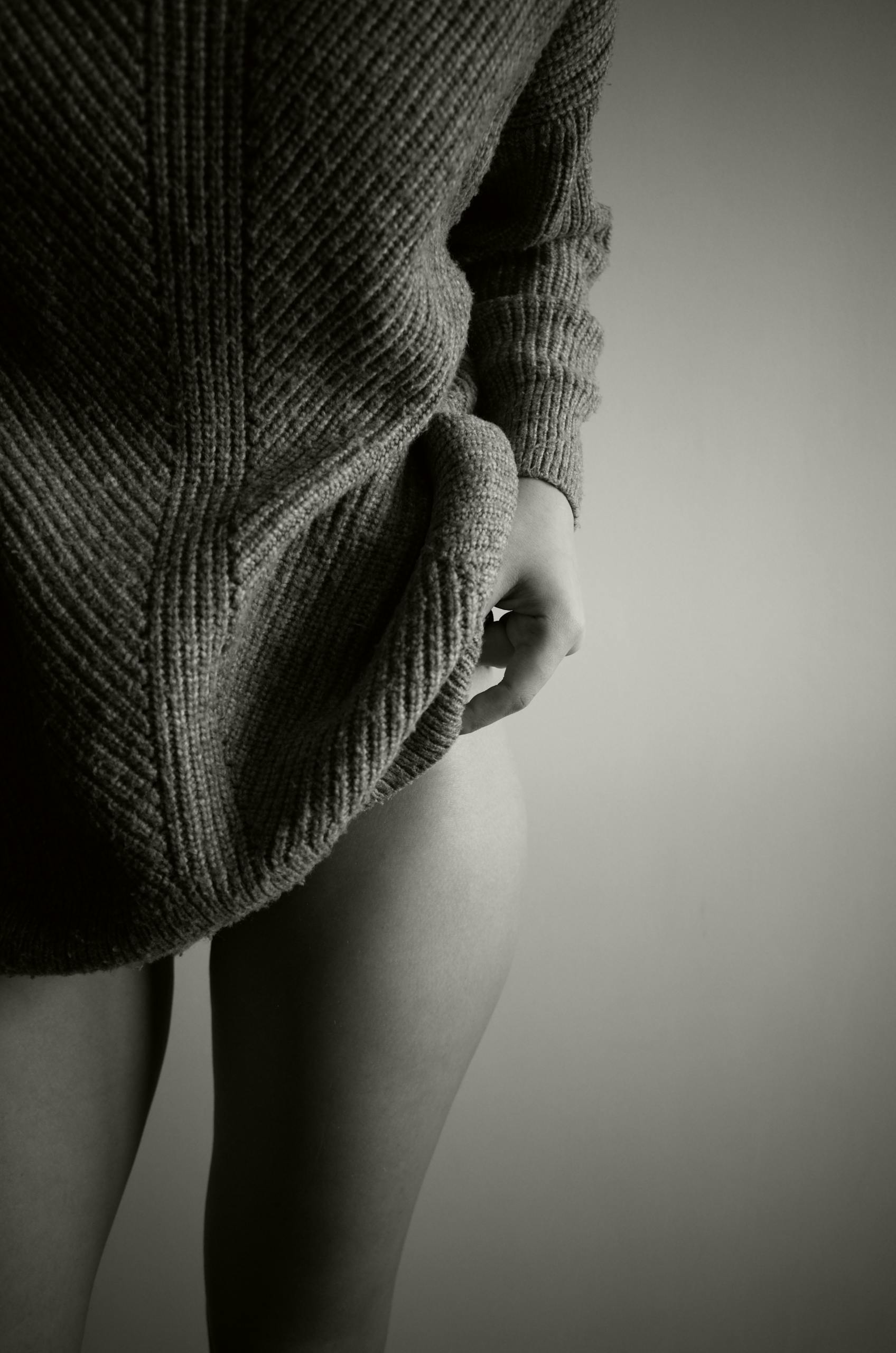 Black and white close-up of a woman in a sweater showcasing texture and elegance.