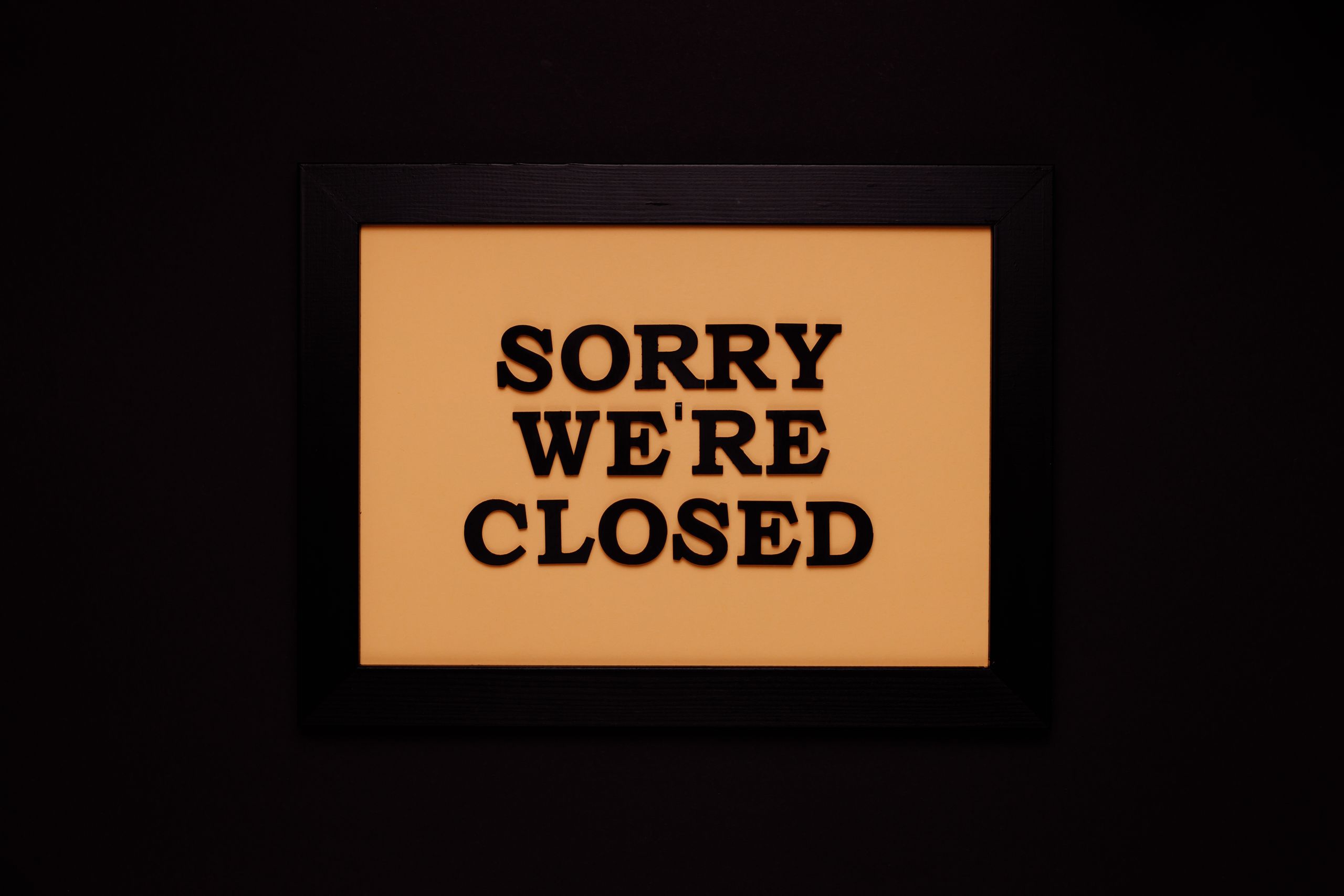 Black-framed 'Sorry We're Closed' sign against a dark backdrop, ideal for business themes.