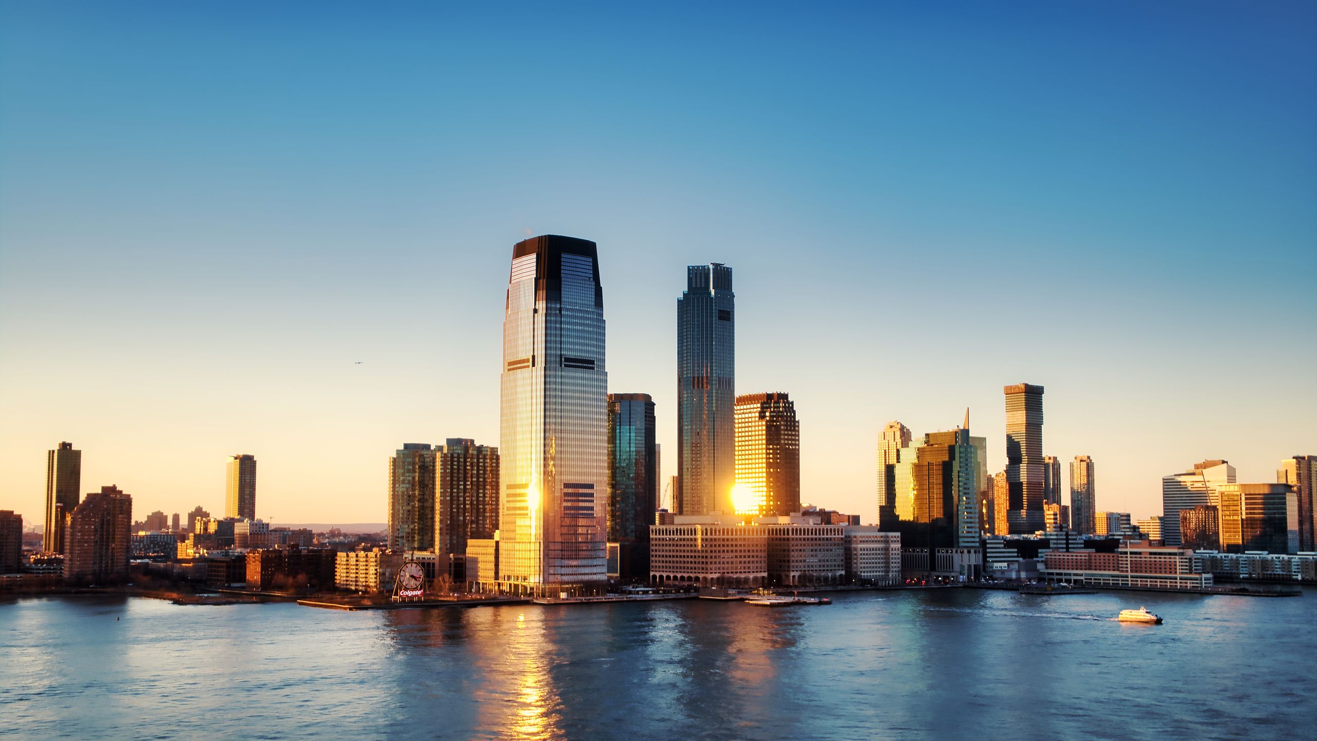 Breathtaking sunrise view over New York City skyline with reflection on the water.