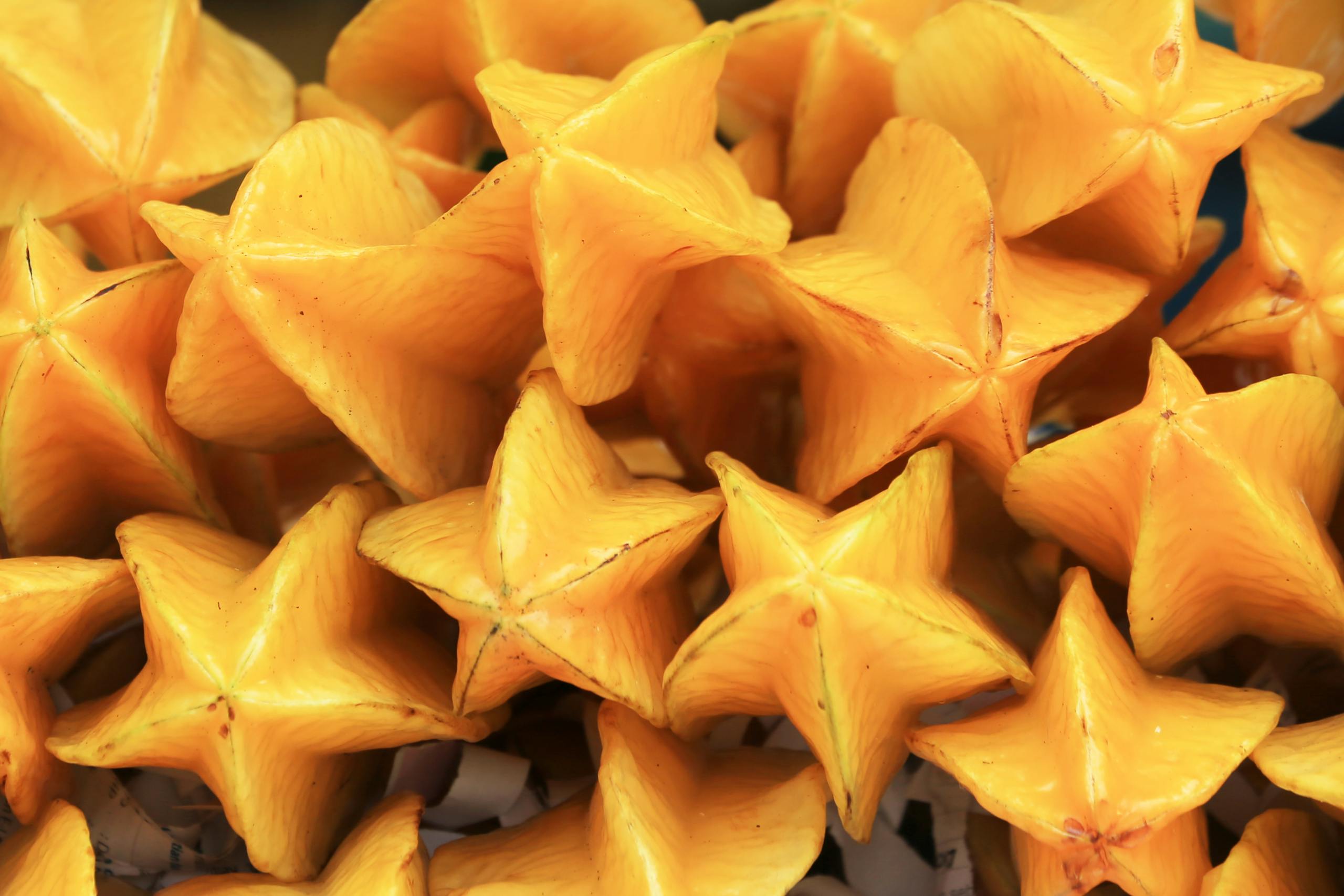 Bright and colorful starfruit (Averrhoa carambola) piled together, showcasing vibrant tropical fruits.