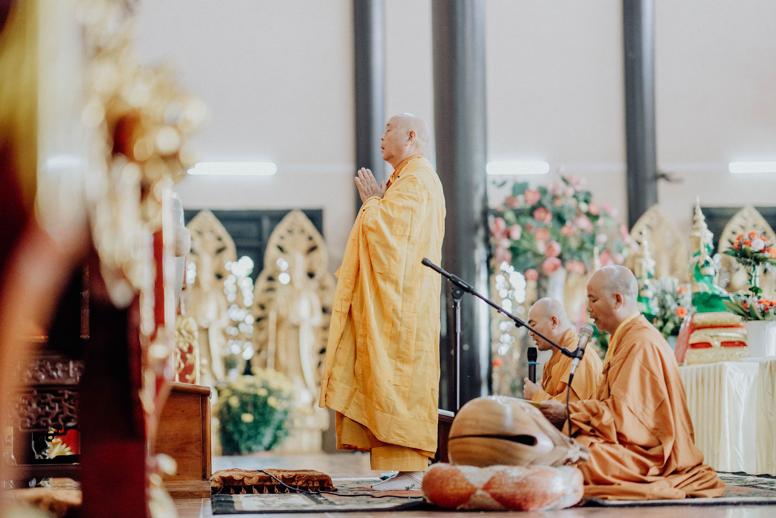 Buddhist monks in a prayer ceremony at a temple in Vietnam, showcasing traditional robes.