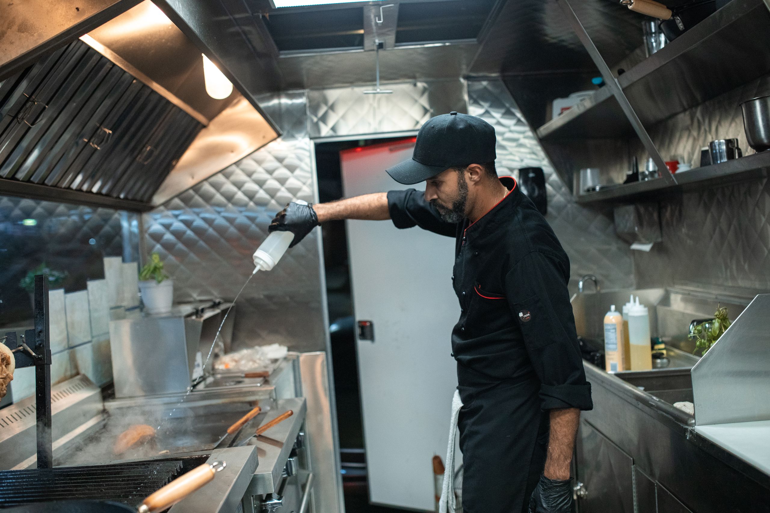 Chef preparing food in a modern industrial kitchen, showcasing culinary skills and food preparation.