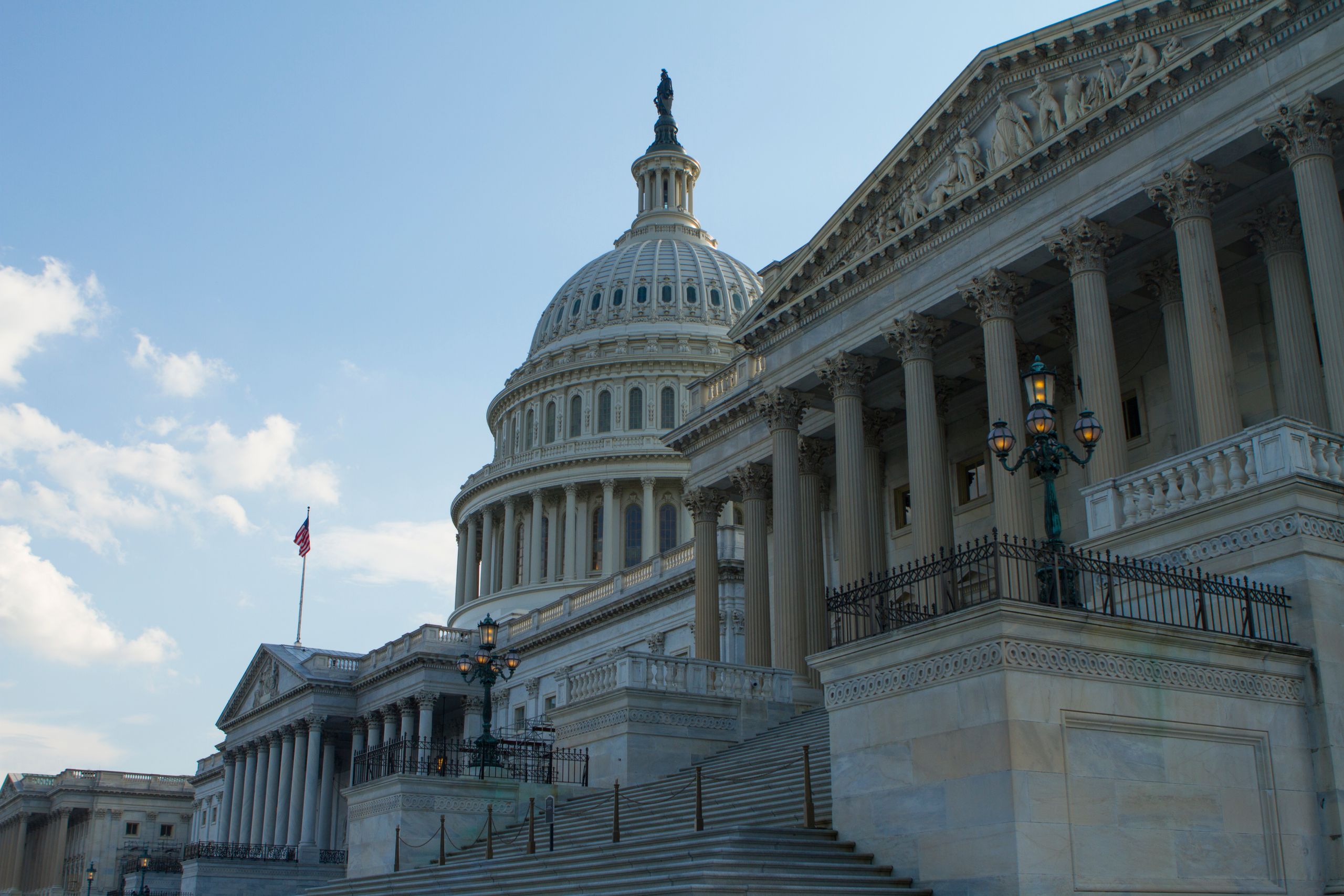 Classic view of the historic US Capitol Building in Washington, DC, with a clear blue sky.