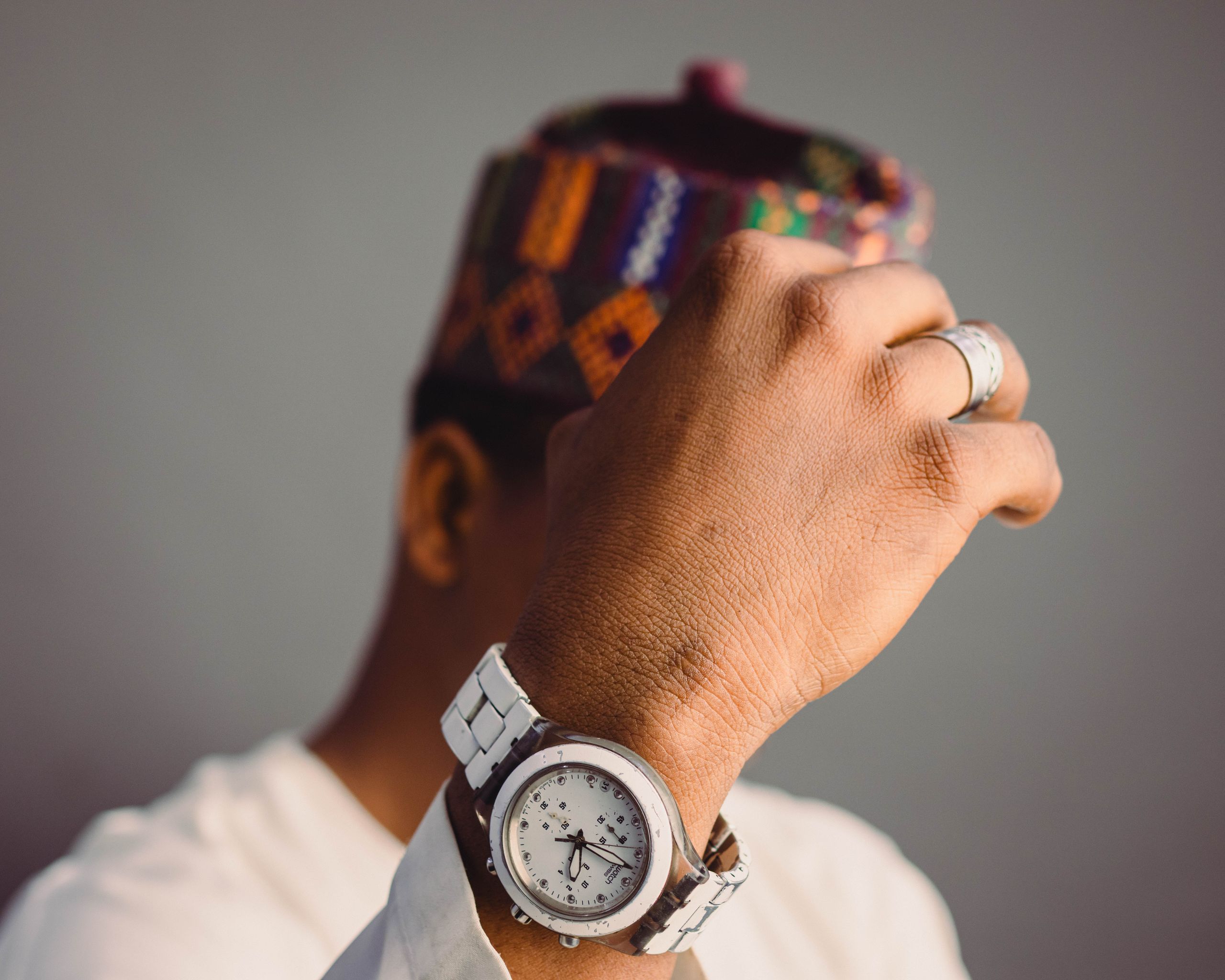 Close-up of a man in traditional clothing showcasing a stylish wristwatch with a focus on detail and elegance.