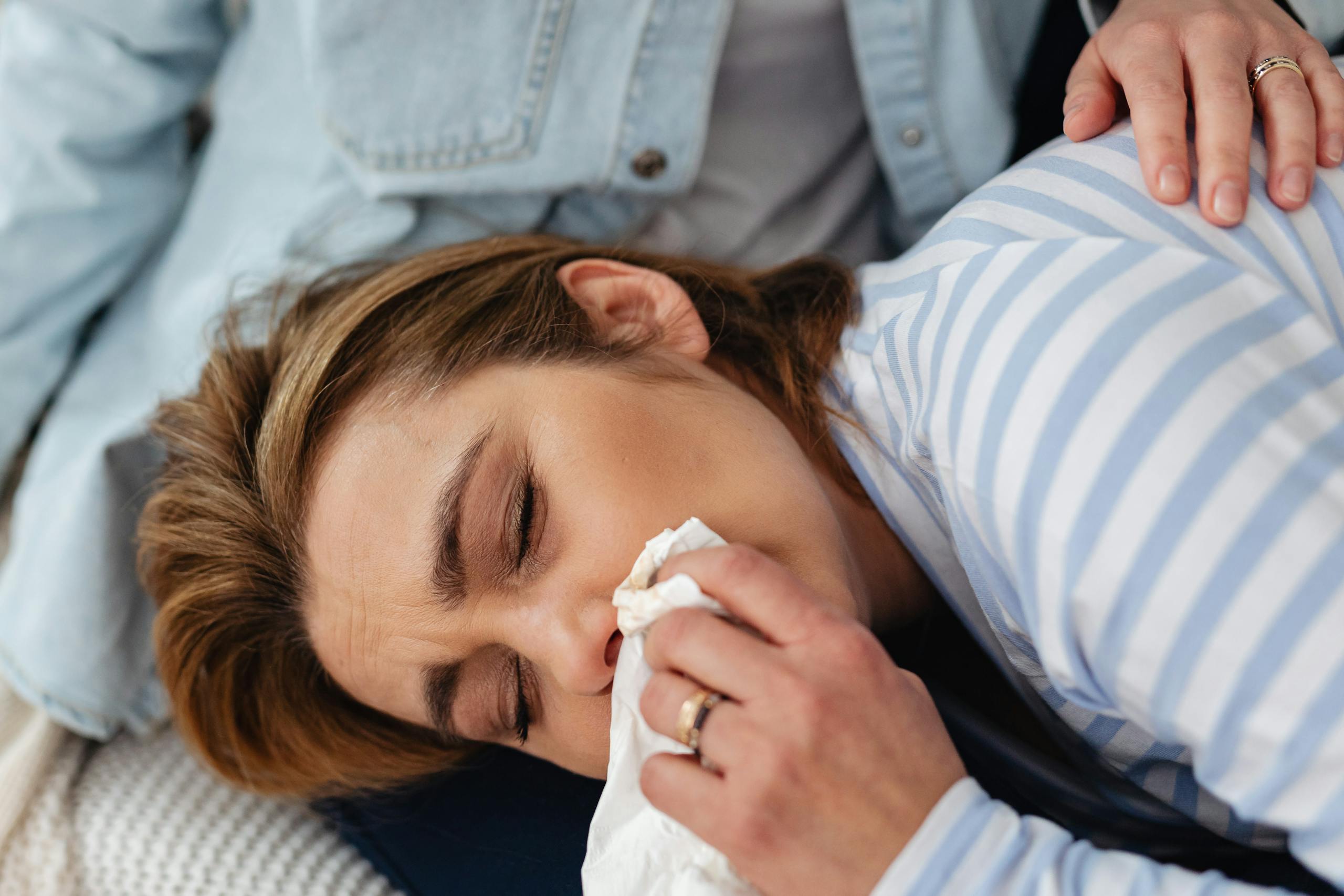 Close-up of a woman in distress being comforted indoors.