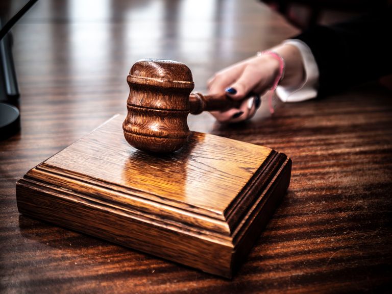 Close-up of a wooden gavel on a judge's desk, symbolizing justice.